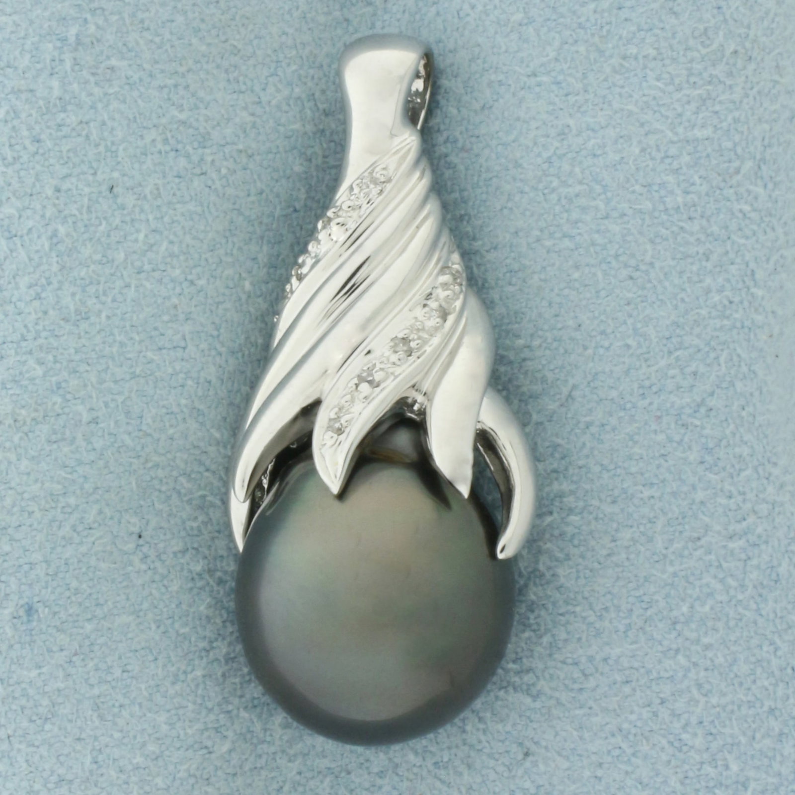 Tahitian Pearl and Diamond Pendant in 18k White Gold: In 18k White Gold. Contains one 18.5x13.5mm high quality natural Tahitian Pearl gemstone with high luster and beautiful peacock undertone. Also contains twelve high quality 1/2pt diamonds. 1 3/8 inch 
