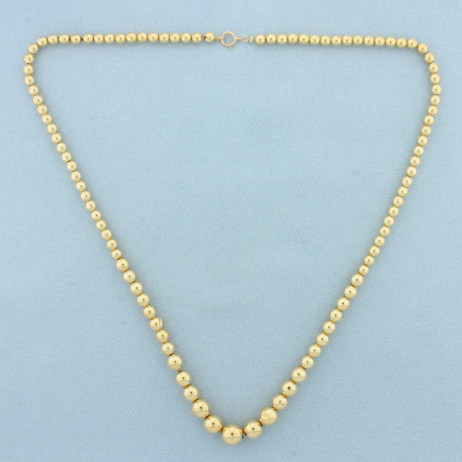 Graduated Gold Ball Bead Necklace in 14k Yellow Gold: In 14k Yellow Gold. 17.5 inches long. 4 to 8mm diameter beads. Spring clasp. 4.4g.
