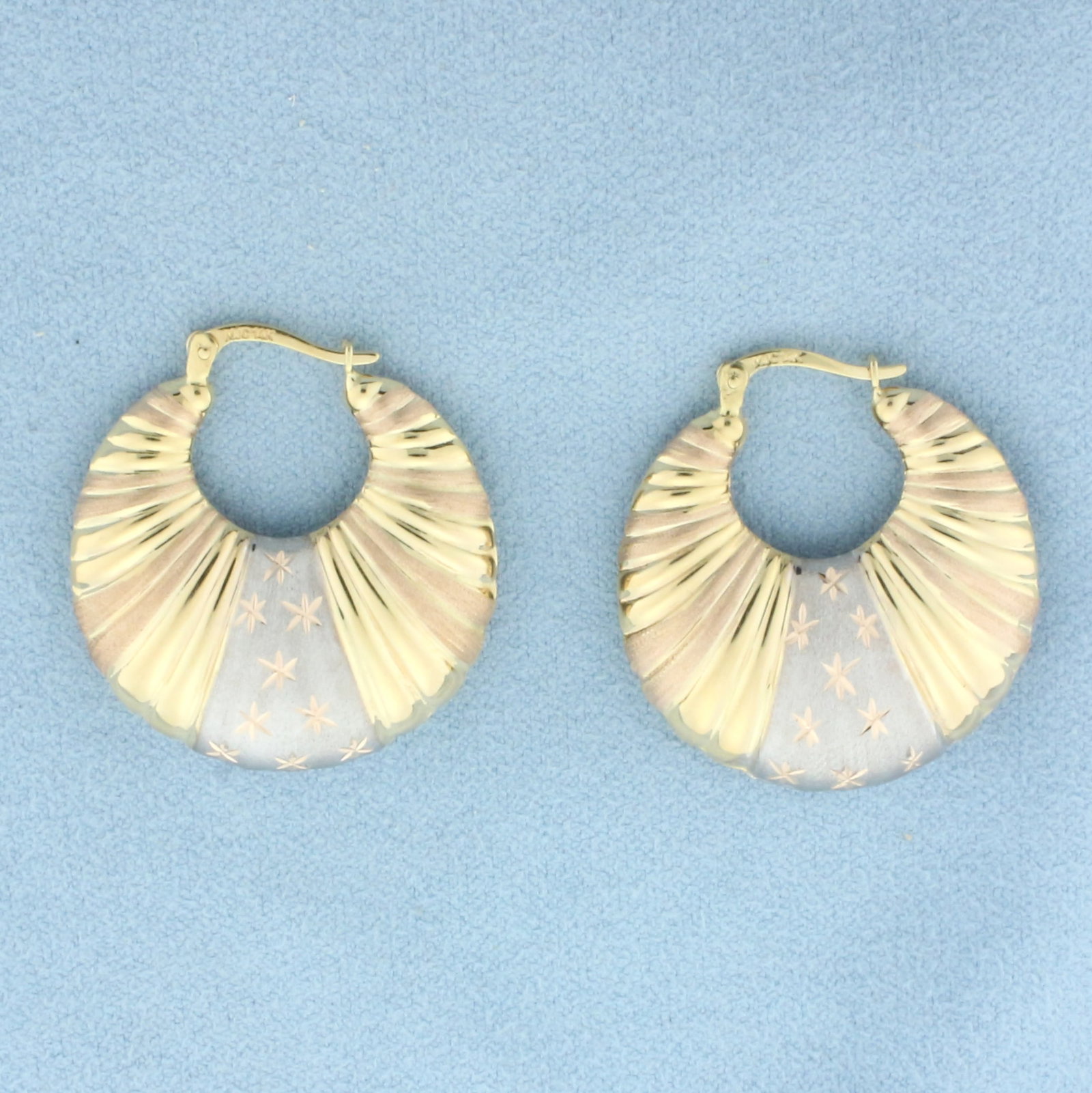 Tri-Color Star Design Hoop Earrings in 14k Yellow, White, and Rose Gold: In 14k yellow, white, and rose gold. 1 1/4 inches long and 1 inch wide. Satin and high polish finish. Leverbacks. 4.7g.