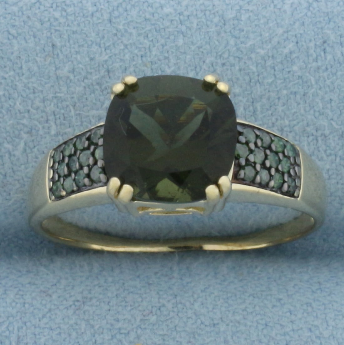 Green Tourmaline Ring in 10k Yellow Gold: In 10k Yellow Gold. Contains one 9mm high quality cushion cut natural Green Tourmaline Gemstone, approximately 2.5ct, with intense color and excellent clarity. Also contains twenty-four 1mm Green Tour