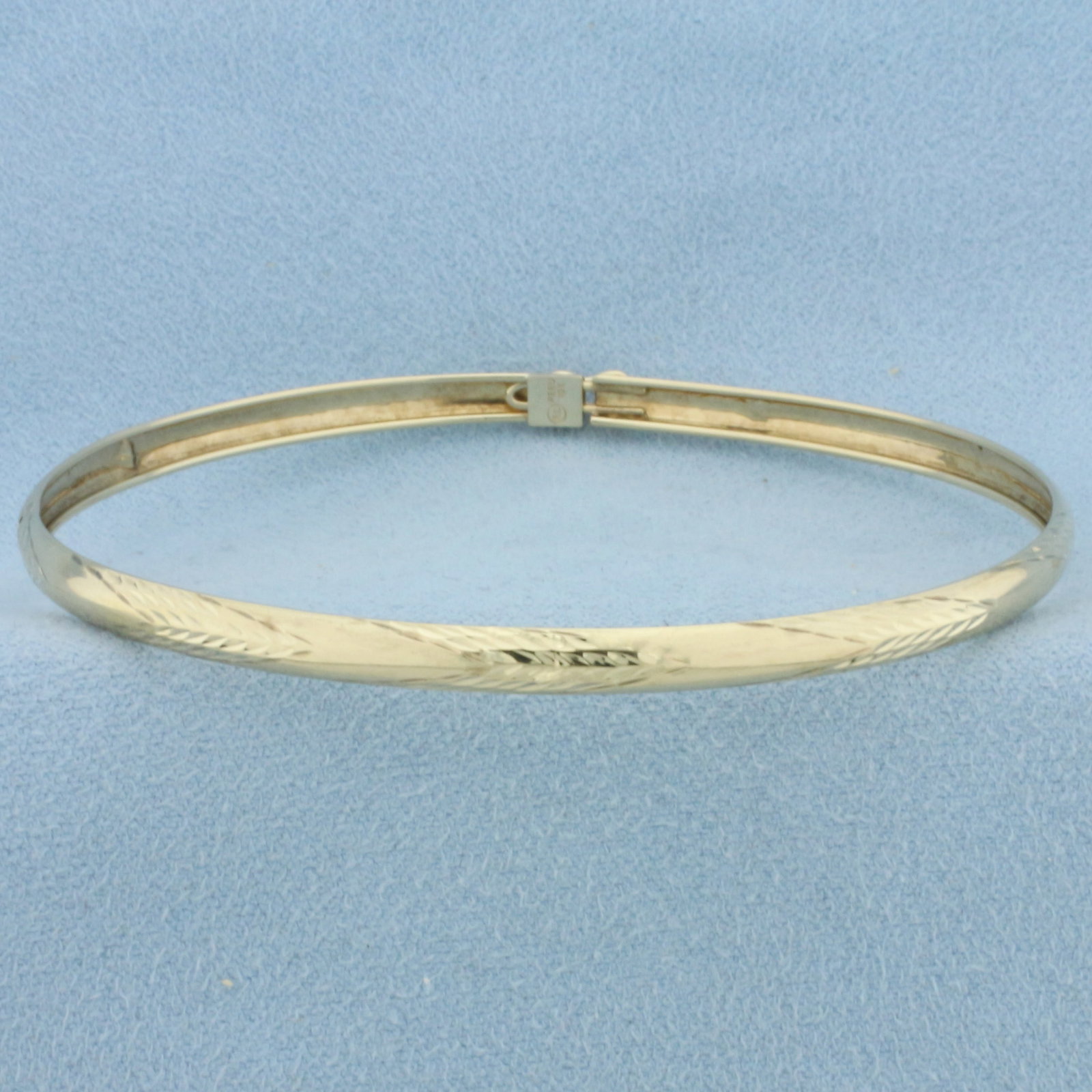 Diamond Cut Bangle Bracelet in 10k Yellow Gold: In 10k Yellow Gold. Interior dimensions: 2 5/8 inch by 2 1/4 inch. 4mm wide. Concealed slide clasp with safety latch. 2.6g.
