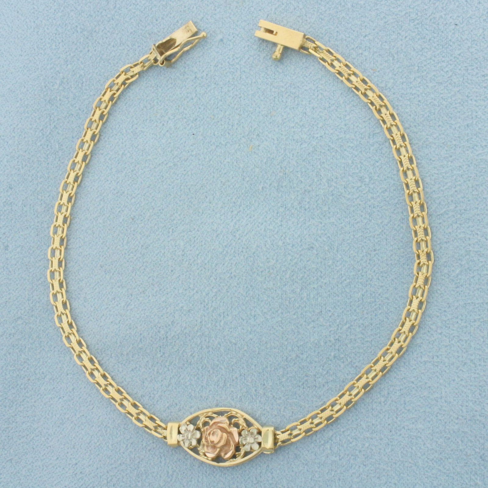 Flower Bracelet in 14k Yellow Gold with Rose and White Gold Accents: In 14k Yellow Gold with Rose and White Gold Accents. 7 inches long. 3/8 inch wide at widest. 3mm wide chain. Slide clasp with safety latch. 3.5g.