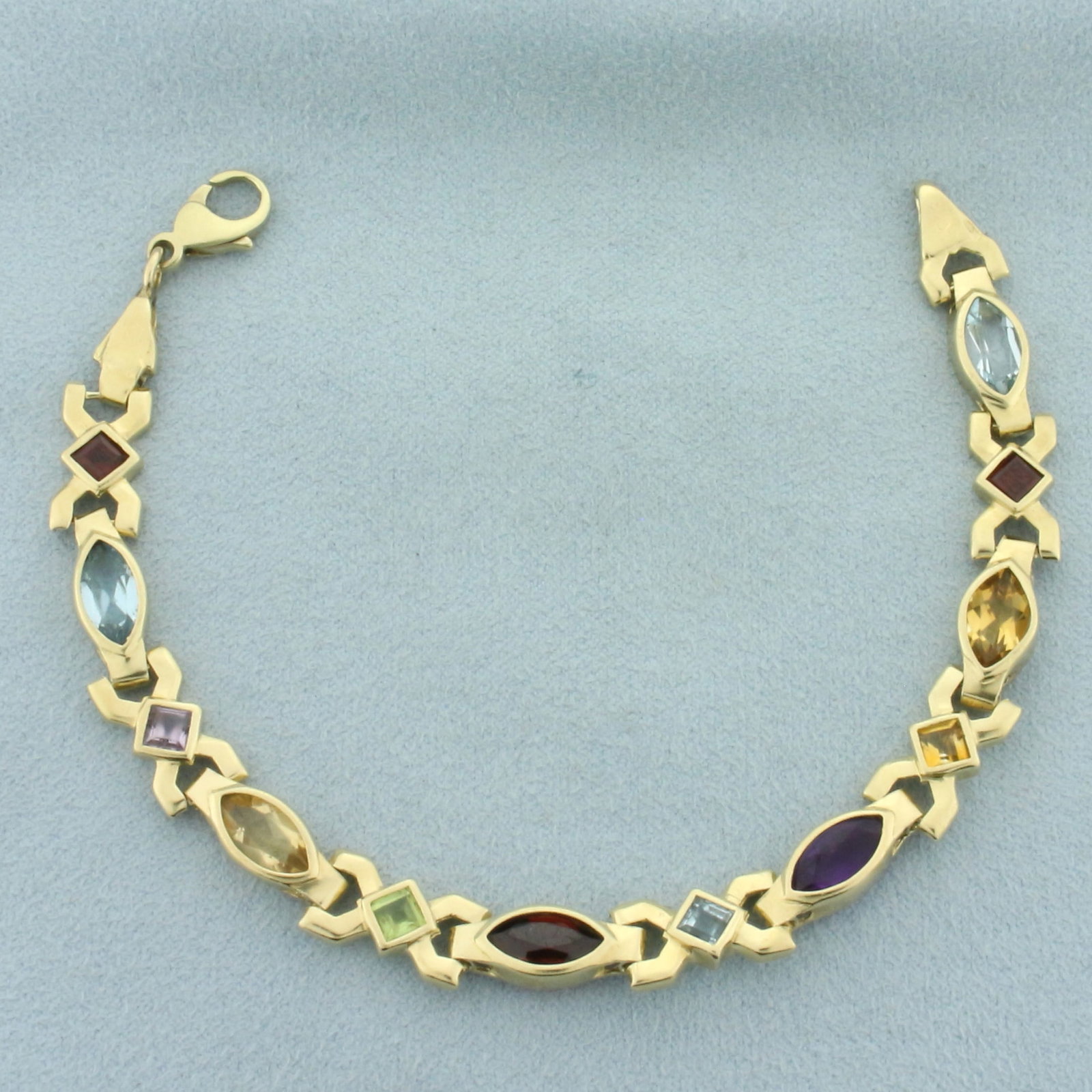 Rainbow Gemstone Geometric Bracelet in 14k Yellow Gold: In 14k yellow gold. Contains 6 high quality natural 10mm marquise shaped gemstones (2 blue topaz, 2 citrine, 1 amethyst, 1 garnet) with bright color and excellent clarity. Also contains 6 high quality