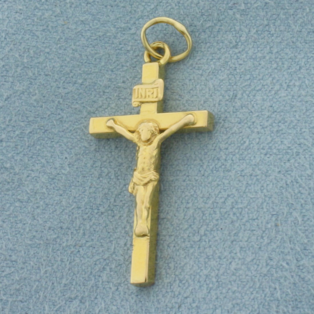 Crucifix Cross Pendant or Charm in 18k Yellow Gold: In 18k Yellow Gold. 1 1/4 inch long (including jump ring). 1/2 inch wide. 1.3g.