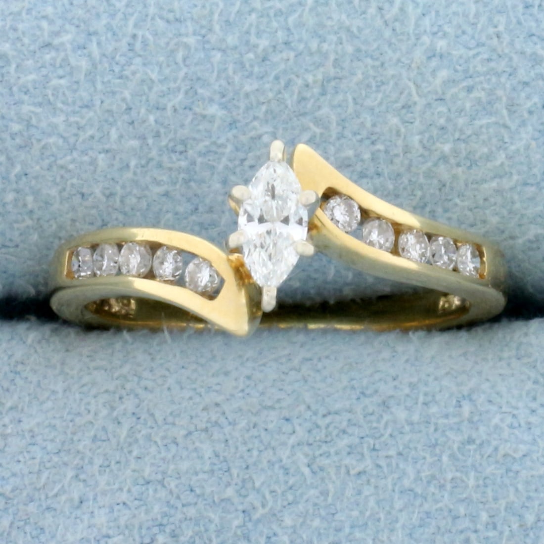 Vintage Marquise and Round Diamond Bypass Engagement Ring in 14K Yellow Gold: In 14K Yellow Gold. Contains a center high quality .3ct marquise shaped diamond, VS clarity/G color. Also contains ten high quality .02ct round cut diamonds, SI clarity/H color. Size 6. 2.8g.