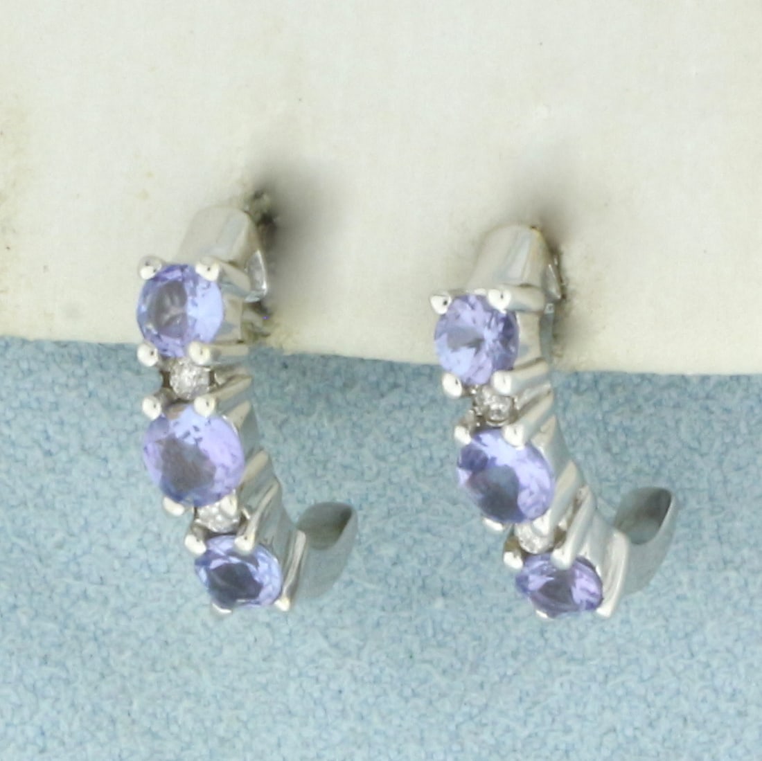 Tanzanite and Diamond Half Hoop Earrings in 14k White Gold: In 14k White Gold. Contains two 3.5mm and four 3mm high quality natural Tanzanite gemstones with bright color and excellent clarity. Also contains four .01ct TW high quality diamonds, I color/I clarit