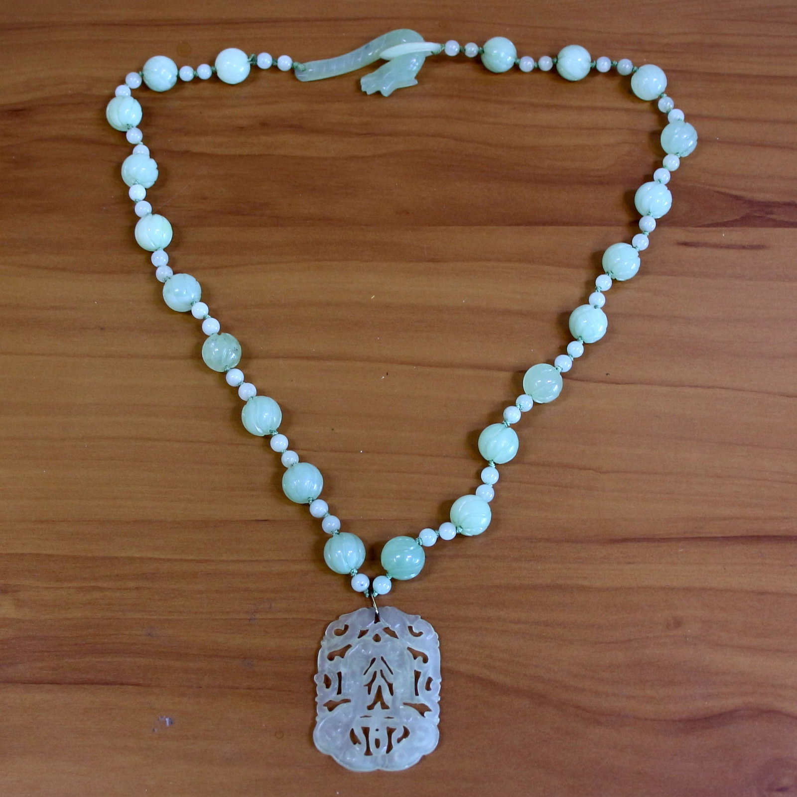 Vintage Carved Jade Bead Necklace: Contains 6mm and 13.5mm high quality carved Jade beads. Dangle drop is 2 inches by 1 5/8 inch. 28 inches long. Hand knotted. 105.9g.