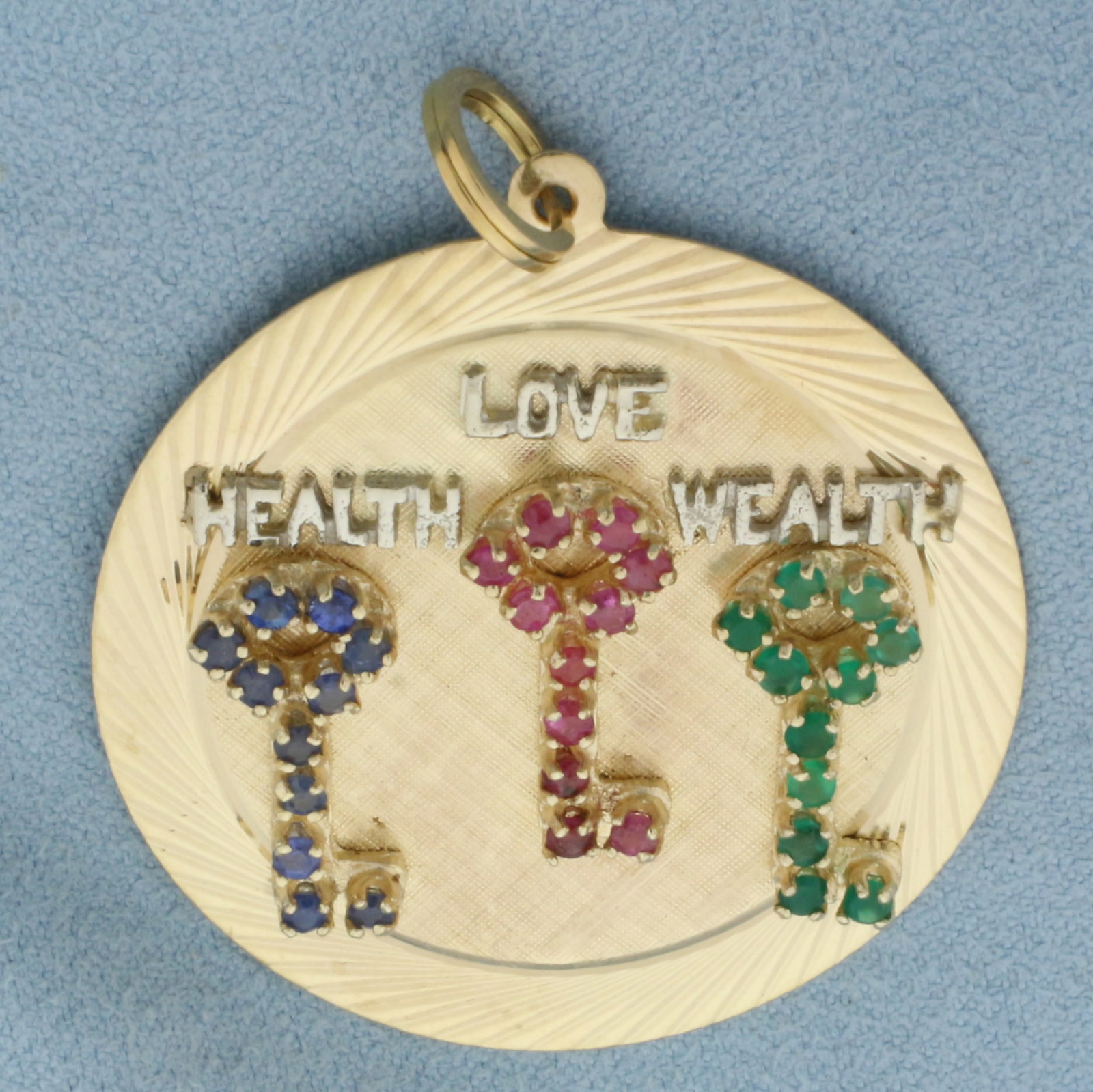 Sapphire, Ruby, and Emerald Health Love Wealth Charm or Pendant in 14K Yellow Gold: In 14k yellow gold with 18k yellow gold split jump ring for easy attachment. 1.75 inches long by 1.50 inches wide. Contains 33 high quality natural Sapphire, Ruby, and Emerald gemstones with vibrant c