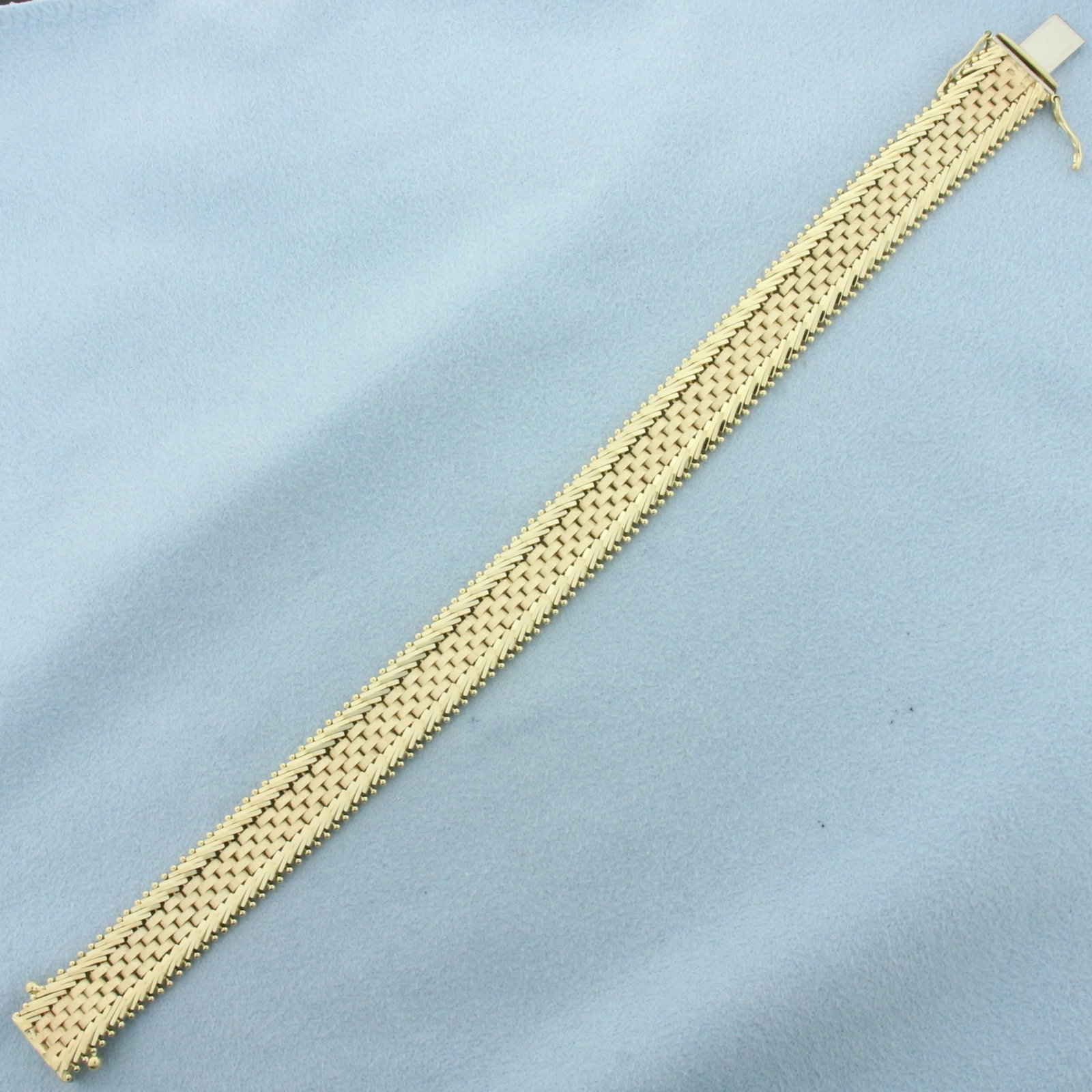 Woven Link Bracelet in 14k Yellow Gold: In 14k yellow gold. 7 1/4 inches long and 11.7mm wide. Concealed slide clasp with 2 safety latches. 25.4g.