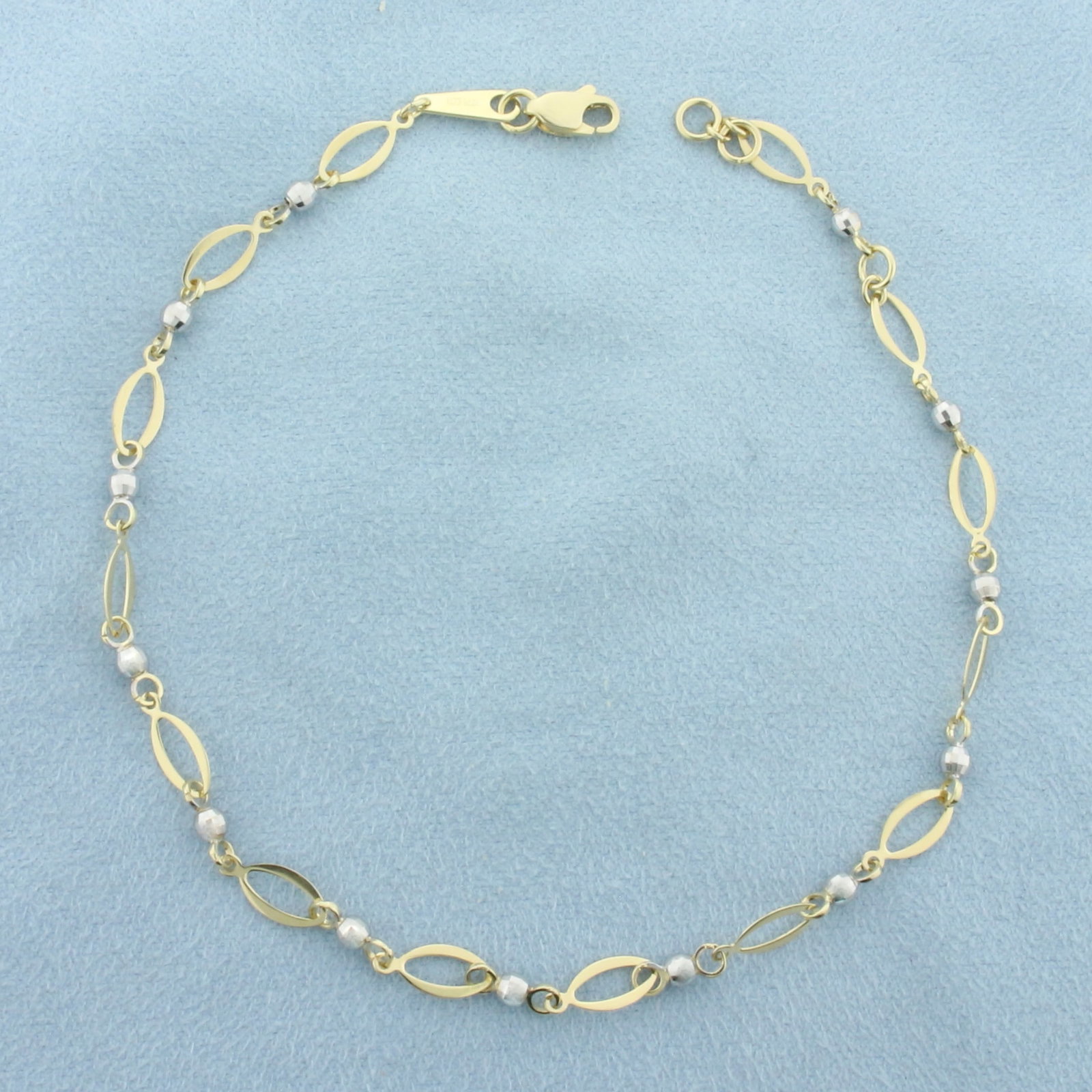 Ball Bead Link Anklet in 14k Yellow and White Gold: In 14k Yellow and White Gold. 10 inches long. 4.5mm wide. Lobster clasp. 3.8g.