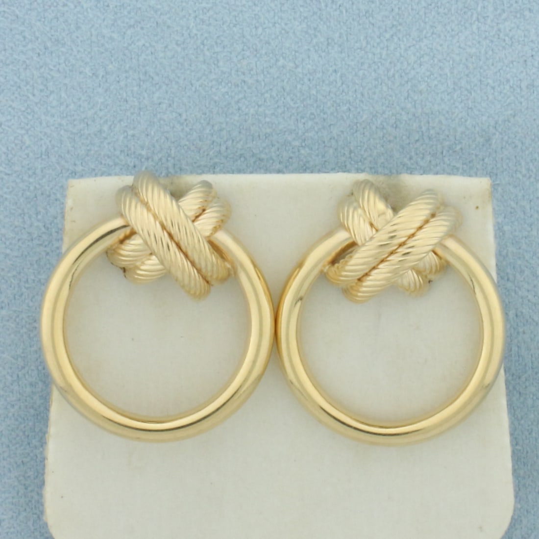 Rope Knot Door Knocker Hoop Earrings in 14k Yellow Gold: In 14k Yellow Gold. 7/8 inch long. 3mm tube. Friction backs. 4.1g.