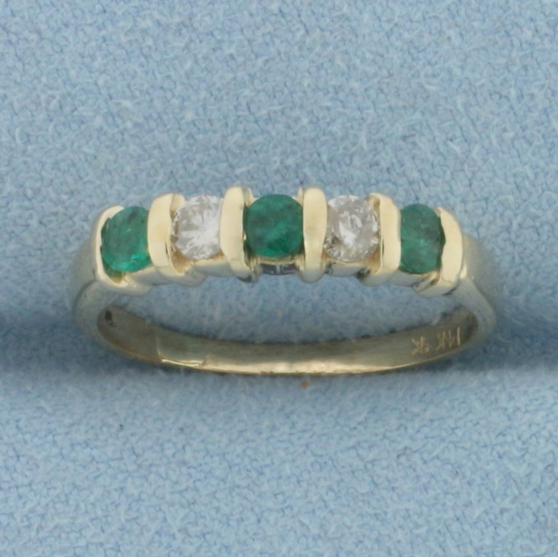 Emerald and Diamond Stacking Ring in 14k Yellow Gold: In 14k Yellow Gold. Contains three 3mm high quality natural Emerald gemstones with vibrant color. Also contains two .10ct high quality diamonds, I color/I1 clarity. Size 6.5. 2.4g.