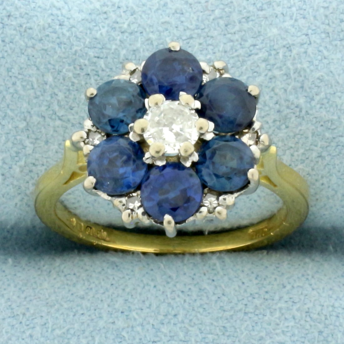 Vintage Sapphire and Diamond Flower Ring in 18k Yellow Gold: In 18k yellow gold. Contains 6 very high AAA quality natural .3ct sapphire gemstones with intense Ceylon blue color and excellent clarity. Also contains a high quality 1/4ct diamond, VS clarity/G colo