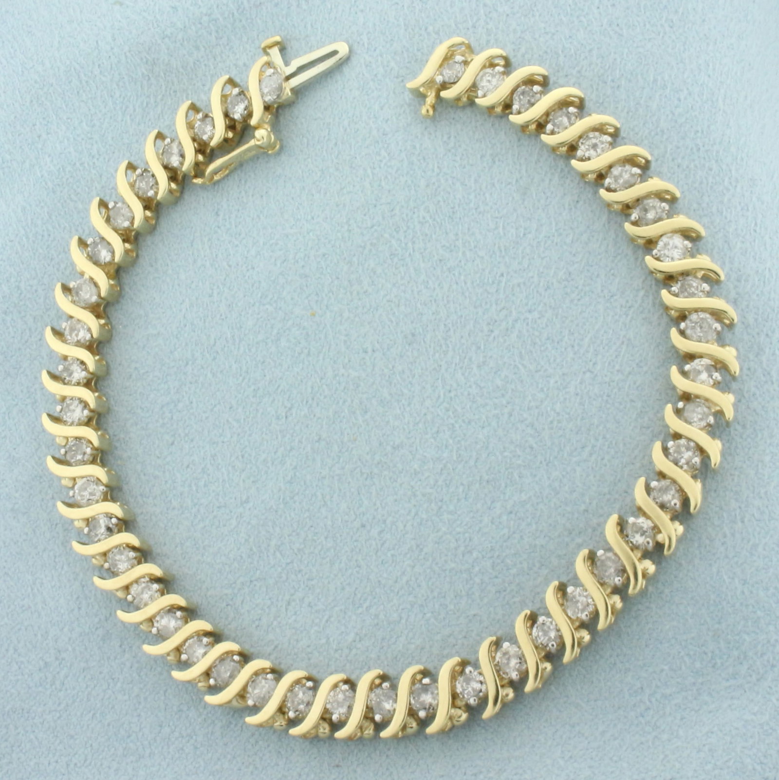 4ct Diamond Tennis Bracelet in 10k Yellow Gold: In 10k yellow gold. Contains 44 high quality diamonds, 4ct TW, I color/I clarity. 7 inches long and 1/4 inches wide. Concealed slide clasp with safety latch. 13.2g.