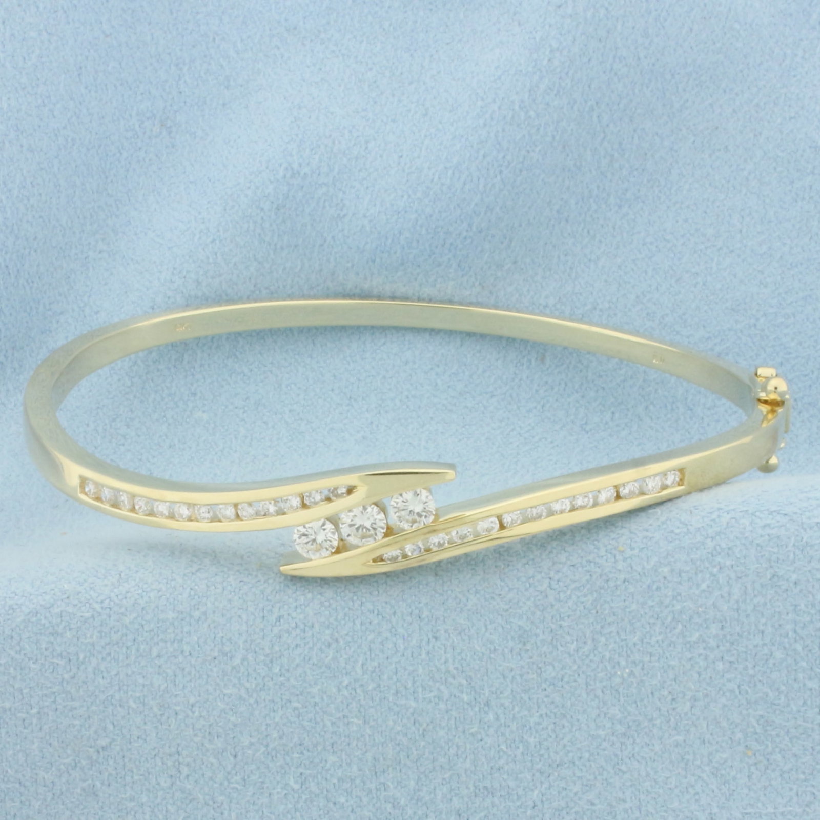 Hinged Diamond Bangle Bracelet in 14K Yellow Gold: In 14k yellow gold. Interior dimensions are 2.375 inches by 2.125 inches. 9mm wide at widest spread on top of bracelet. Contains three 1/8ct and twenty six .02ct high quality round brilliant diamonds,