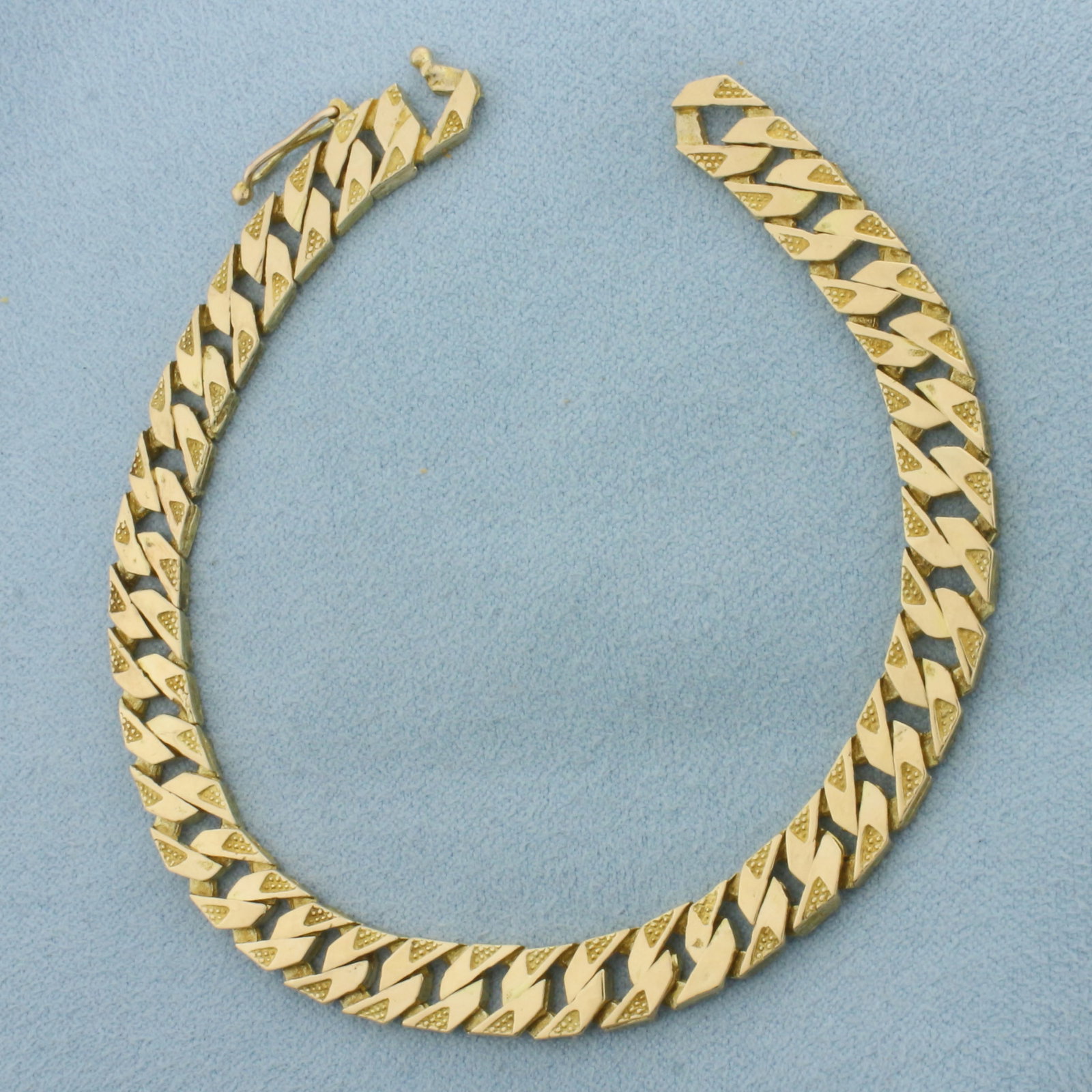 Textured Curb Link Bracelet in 19k Yellow Gold: In 19k Yellow Gold. 7 7/8 inches long. 6.9mm wide. Hidden link clasp with safety latch. Stamped "C 795". 14.8g.