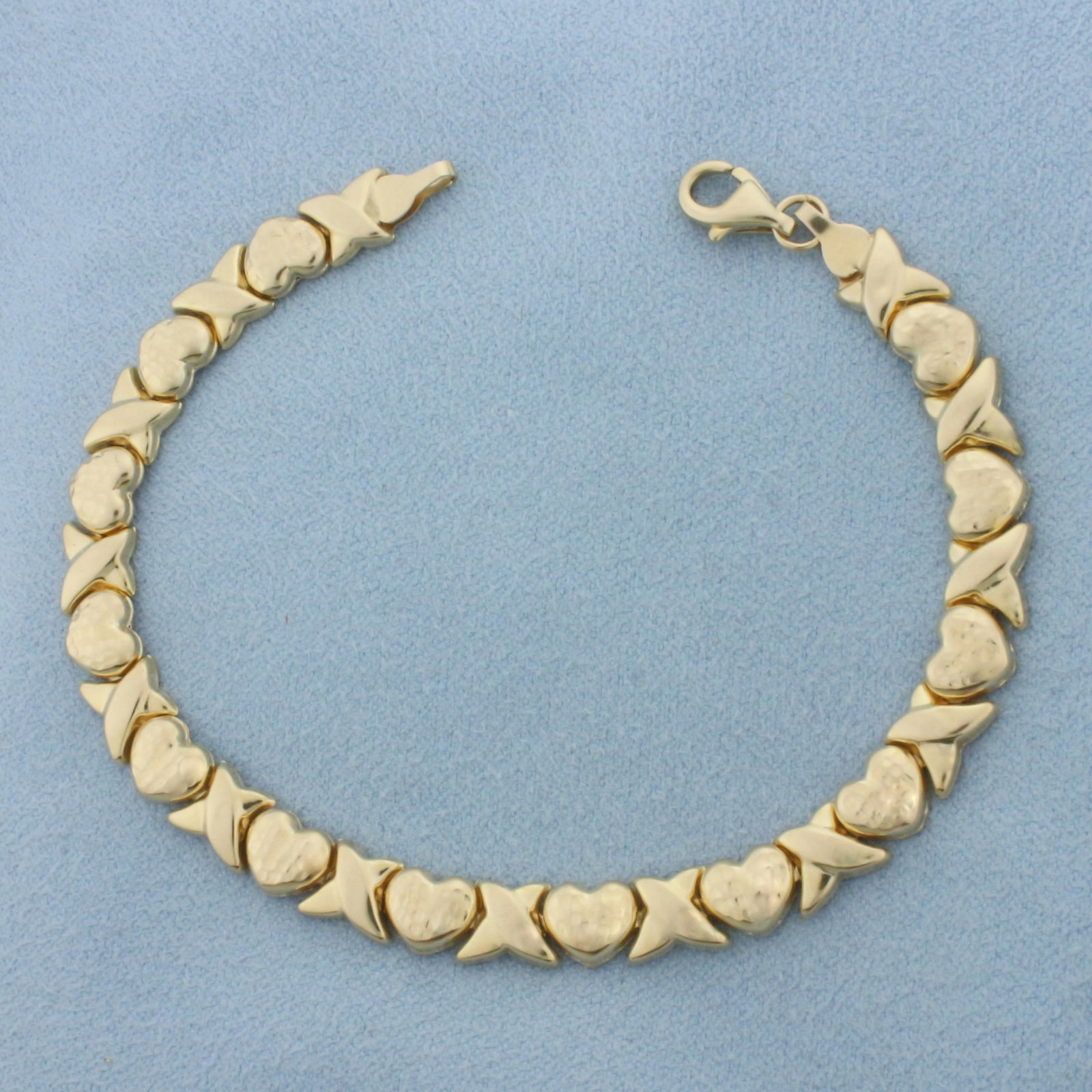 Heart Hugs and Kisses Link Bracelet in 10k Yellow Gold: In 10k Yellow Gold. 7 1/8 inches long. 6.2mm wide. Lobster clasp. 4.3g.