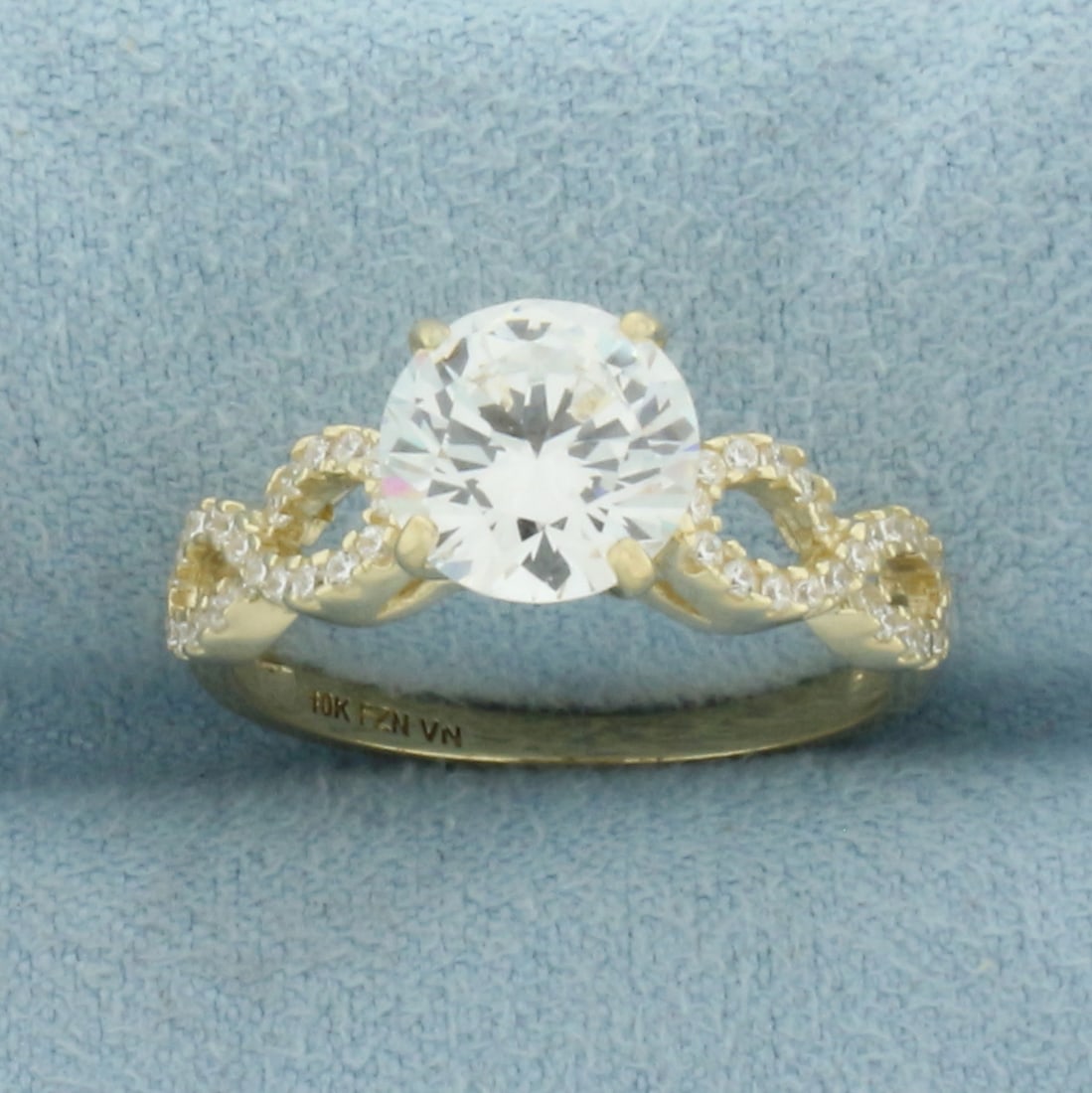 CZ Engagement Ring in 10K Yellow Gold: In 10k Yellow Gold. Contains one 8mm and forty six 1mm high quality CZ gemstones, over 2ct TW, with excellent cut and clarity for added sparkle. Size 7. 2.7g.
