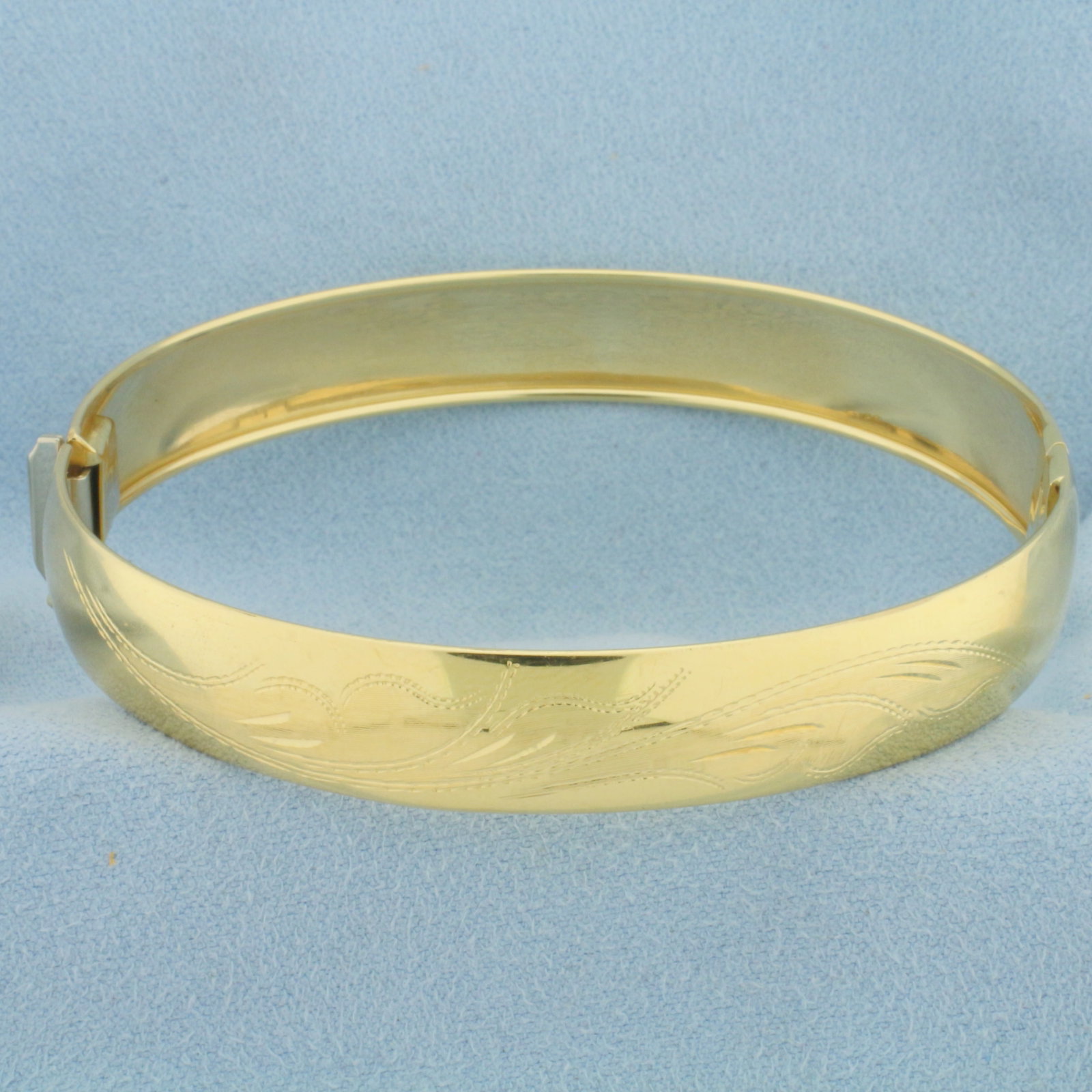 Etched Flower Design Bangle Bracelet in 18k Yellow Gold: In 18k Yellow Gold. Interior dimensions: 2 1/2 inch by 2 3/8 inch. 10.5mm wide. Slide clasp with safety latch. Etched flower design. 14.9g.