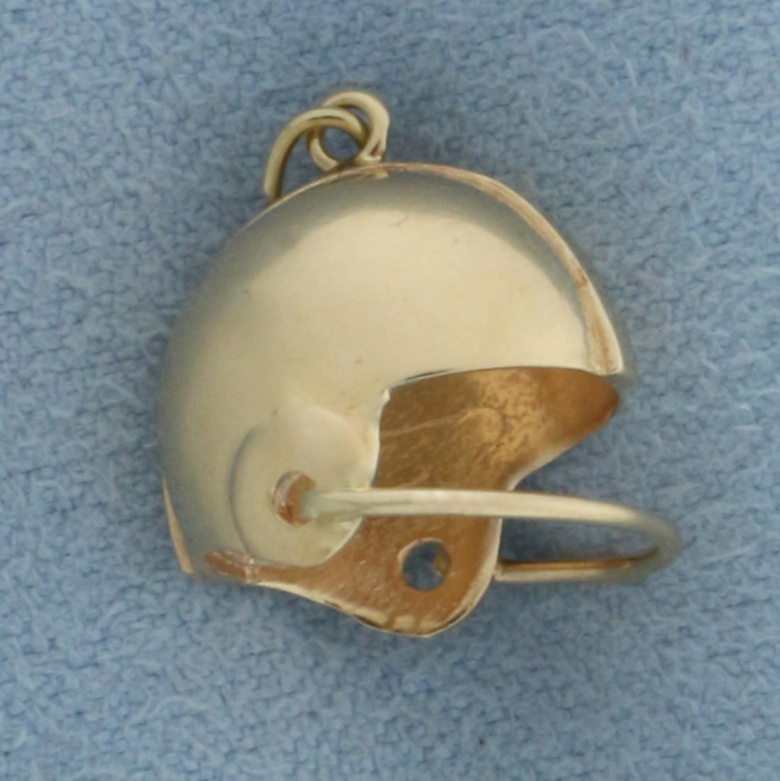 Football Helmet Charm in 14k Yellow Gold: In 14k Yellow Gold. 1/2 inch long. 1/2 inch wide. 2.9g.