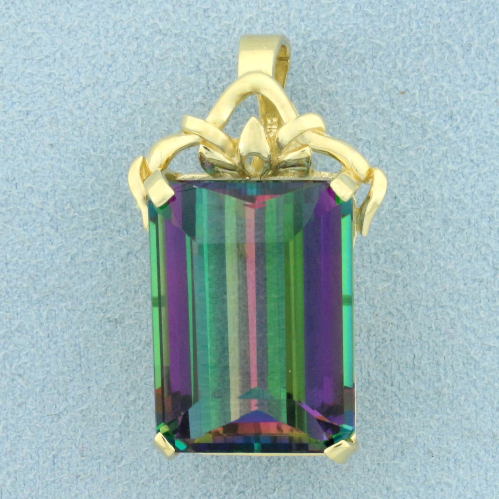 Large Mystic Topaz Statement Pendant in 14K Yellow Gold: In 14K Yellow Gold. Contains one high quality natural 22x16mm emerald cut mystic topaz gemstone with vibrant color and excellent clarity. 1 1/4 inches long, 3/4 inch wide. Bail opens/closes for easy p