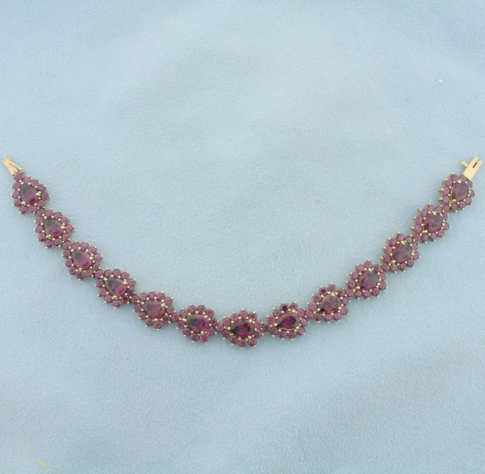 18ct Purple Tourmaline Bracelet in 10k Yellow Gold: In 10k yellow gold. Contains thirteen 7x5mm pear cut and 143 2.5mm round high quality natural Tourmaline gemstones with intense purple color and excellent clarity. Approximately 18ct TW. 6 1/2 inches 