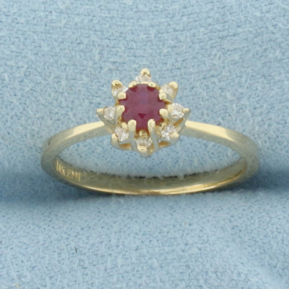 Ruby and Diamond Halo Flower Ring in 14k Yellow Gold: In 14k Yellow Gold. Contains one 4mm high quality natural Ruby gemstone with vibrant color and excellent clarity. Also contains eight high quality .01ct diamonds, H color/SI clarity. 7.4mm wide at top
