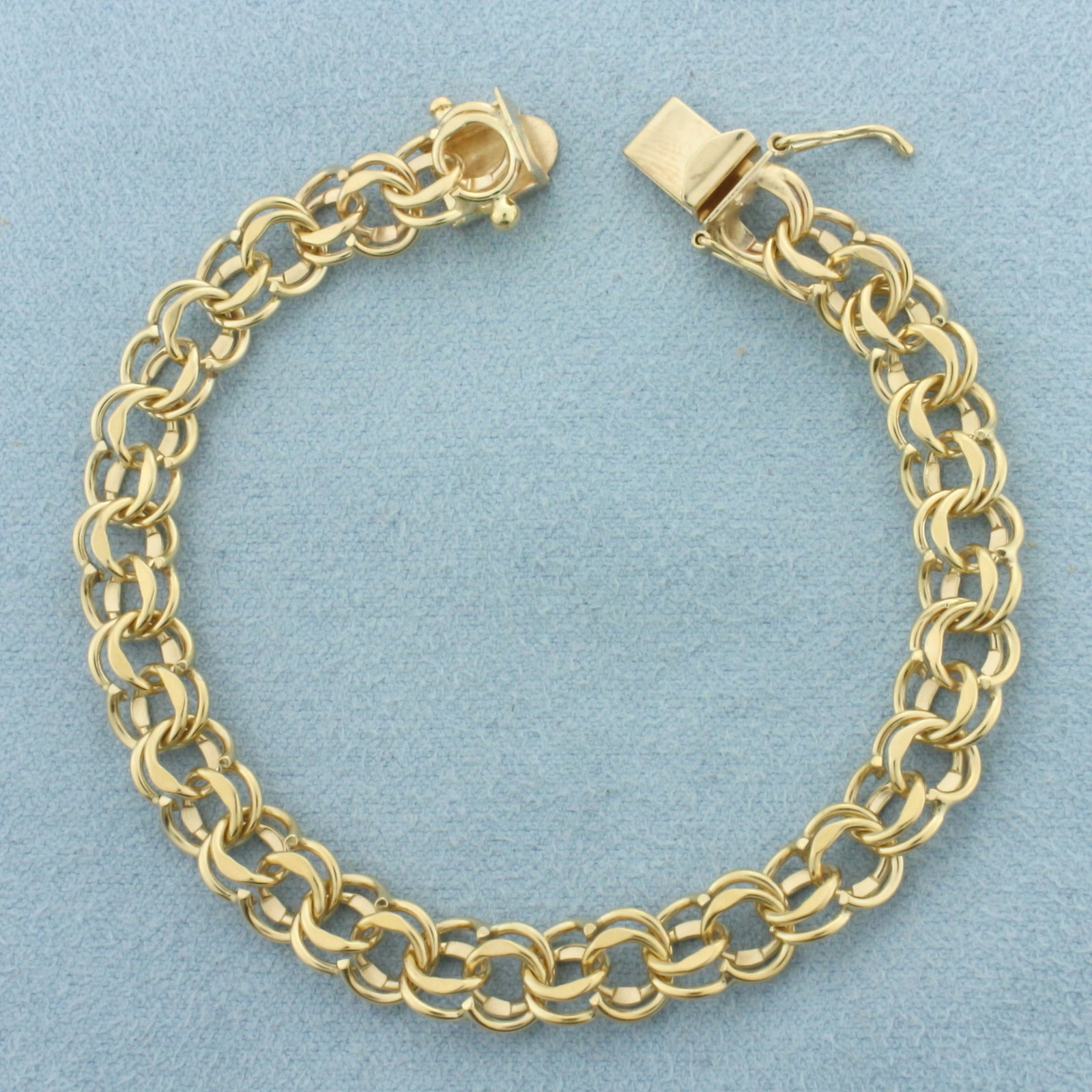 Double Circle Link Charm Bracelet in 14k Yellow Gold: In 14k Yellow Gold. 6 5/8 inches long. 7mm wide. Concealed slide clasp with safety latch. 11.1g.
