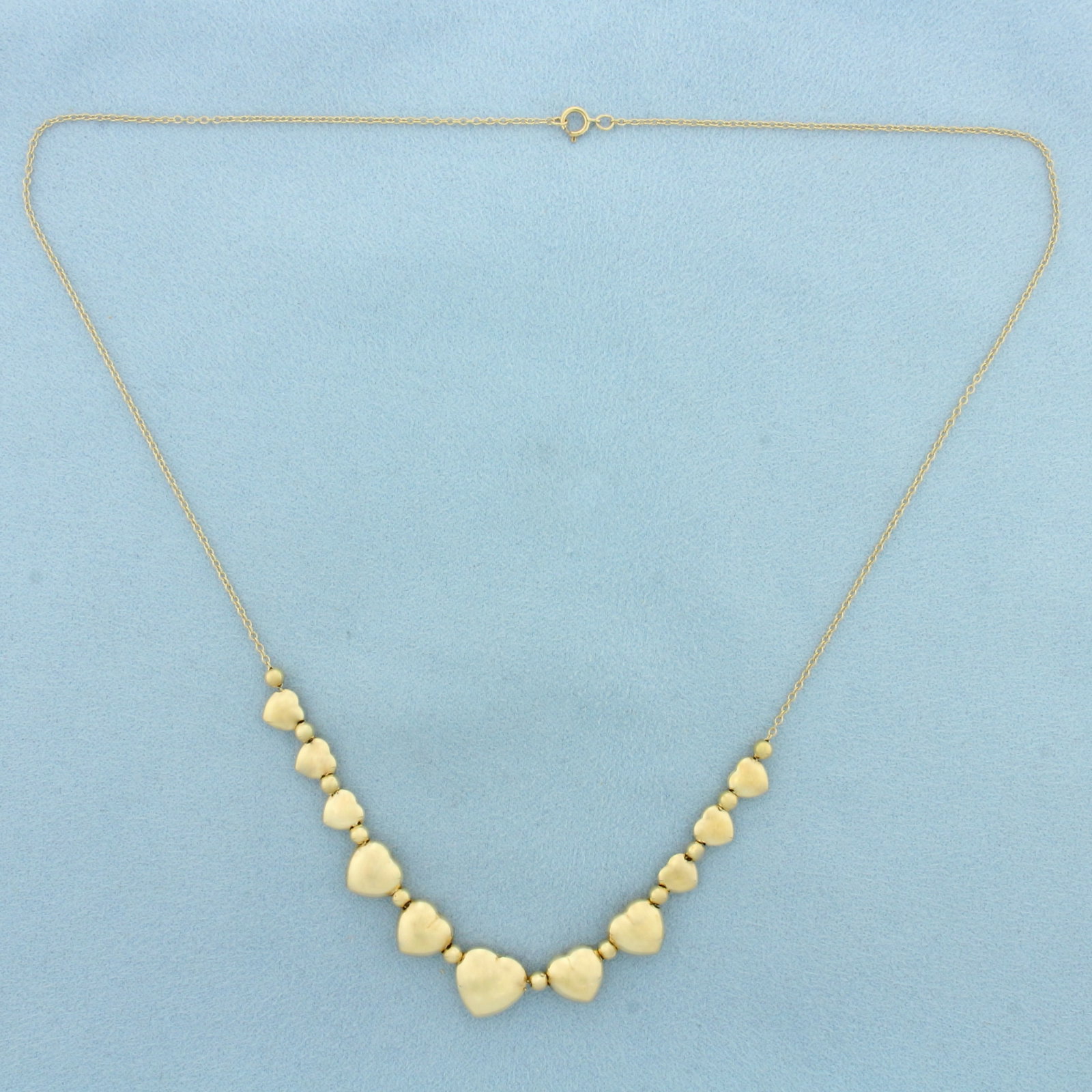 Puffy Heart and Gold Bead Necklace in 14k Yellow Gold: In 14k Yellow Gold. 18 inches long. Largest heart is 10.5mm. Cable link chain .75mm thick. Spring clasp. 3.5g.