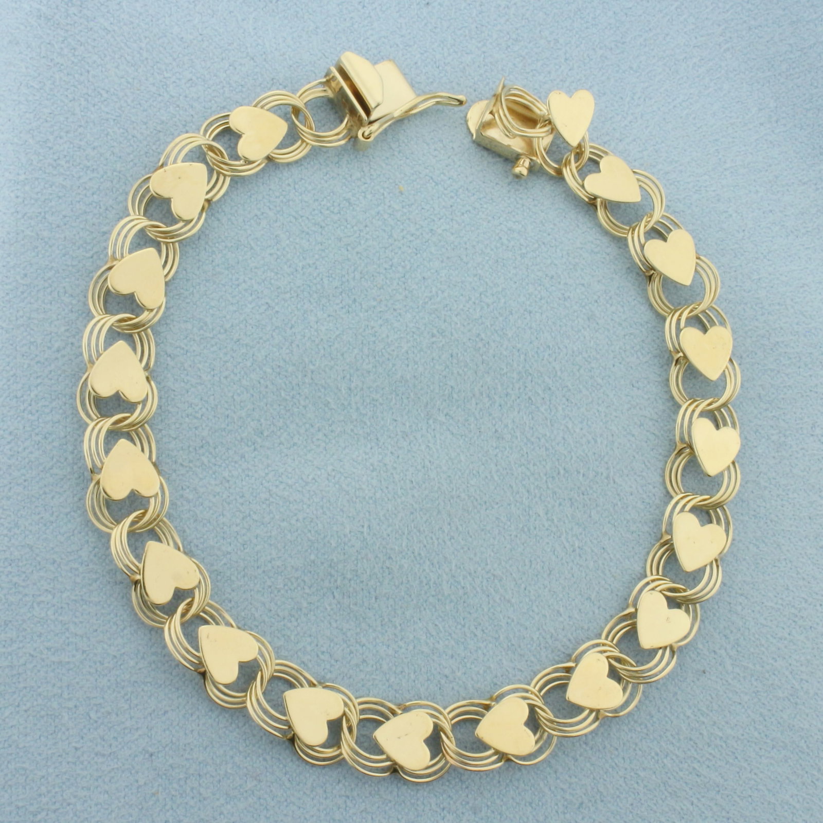 Heart Link Bracelet in 14k Yellow Gold: In 14k Yellow Gold. 7 inches long. 7.5mm wide. Concealed slide clasp with safety latch. Can be used as charm bracelet or as is. 7.5g.
