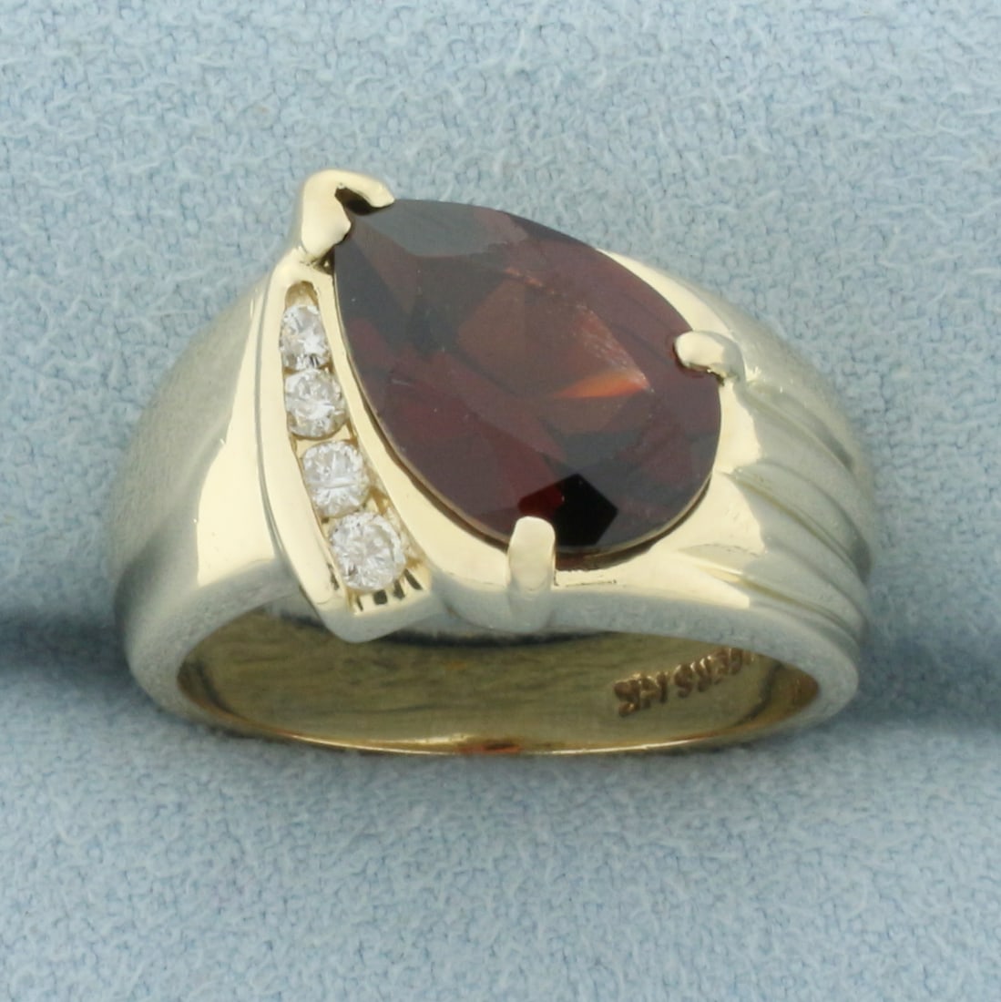Garnet and Diamond Ring in 14k Yellow Gold: In 14k yellow gold. Contains one pear shaped garnet, 12 x 8mm, approx. 3.5cts, with deep color and excellent clarity. Accented by 4 high quality round brilliant cut diamonds, 1/10ct TW, SI clarity/H