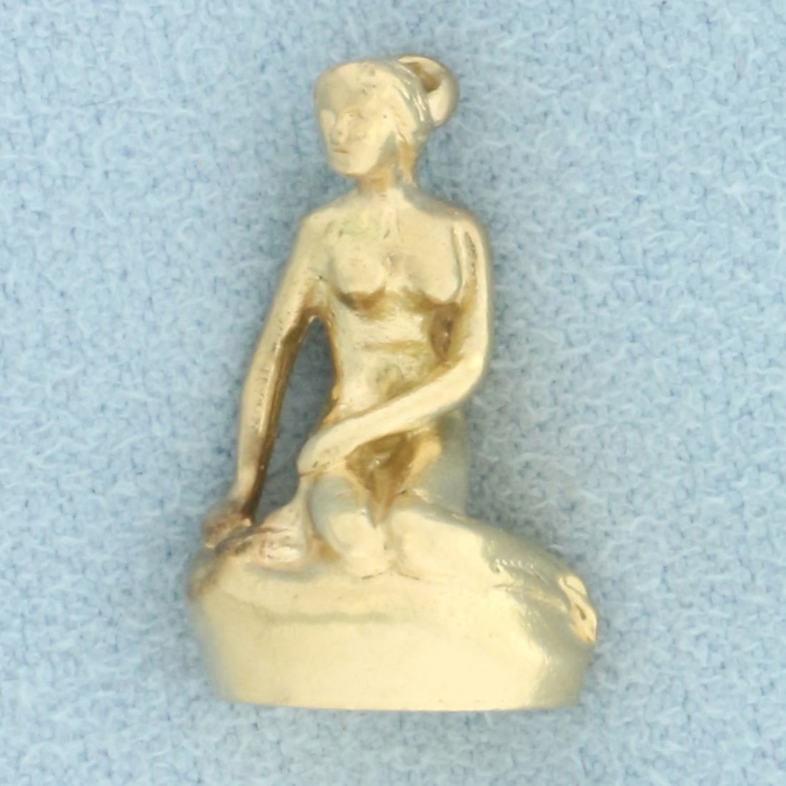 The Little Mermaid of Copenhagen Denmark Pendant or Charm in 14k Yellow Gold: In 14k yellow gold. Reproduction of the statue in Langelinie Pier in Copenhagen. Made in Denmark. 5/8 inches long and 3/8 inches wide. 3-D. 4.6g.