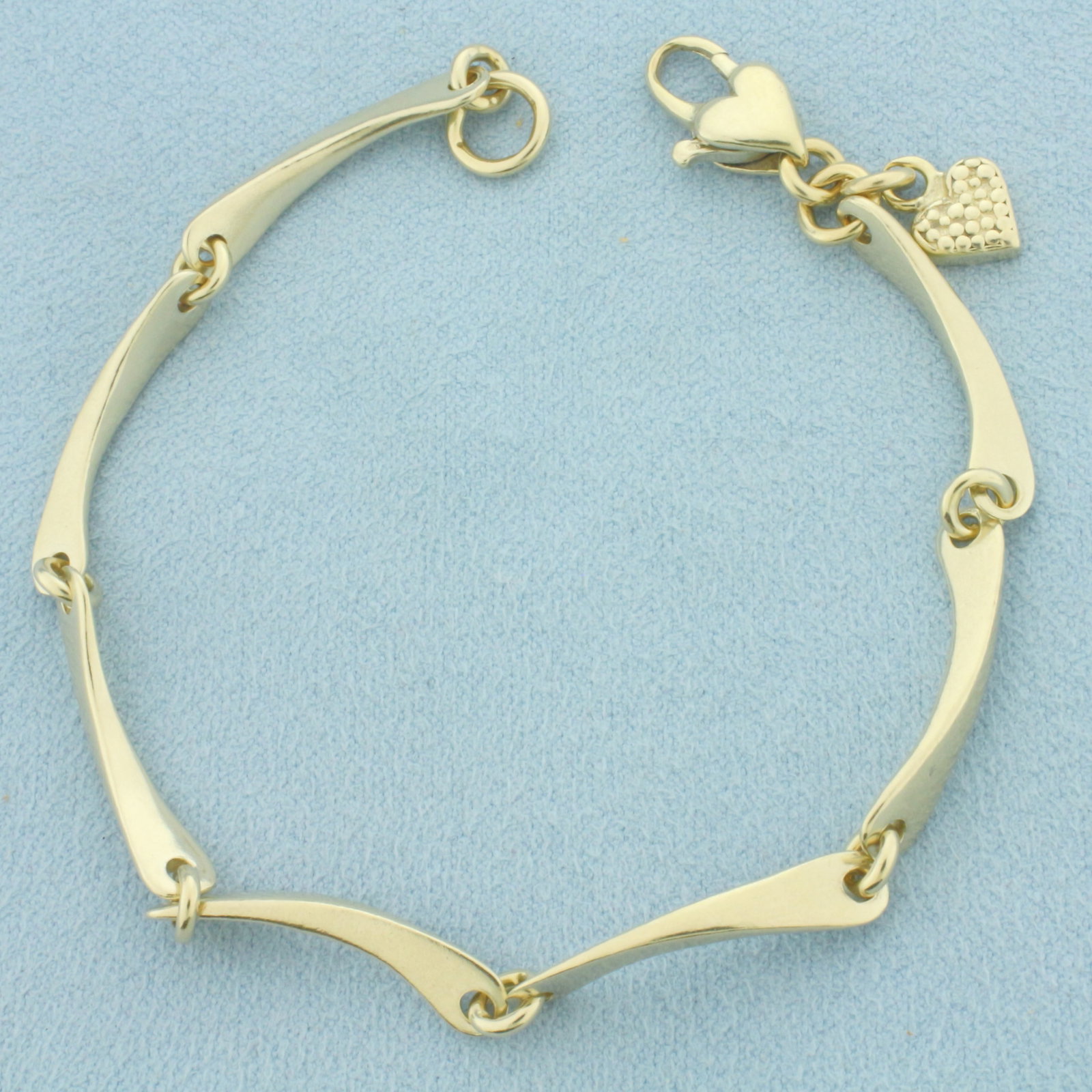 Heart Clasp Wave Bar Link Bracelet in 14k Yellow Gold: In 14k Yellow Gold. 7 5/8 inches long. 4.2mm wide. Spring clasp. 12.6g.