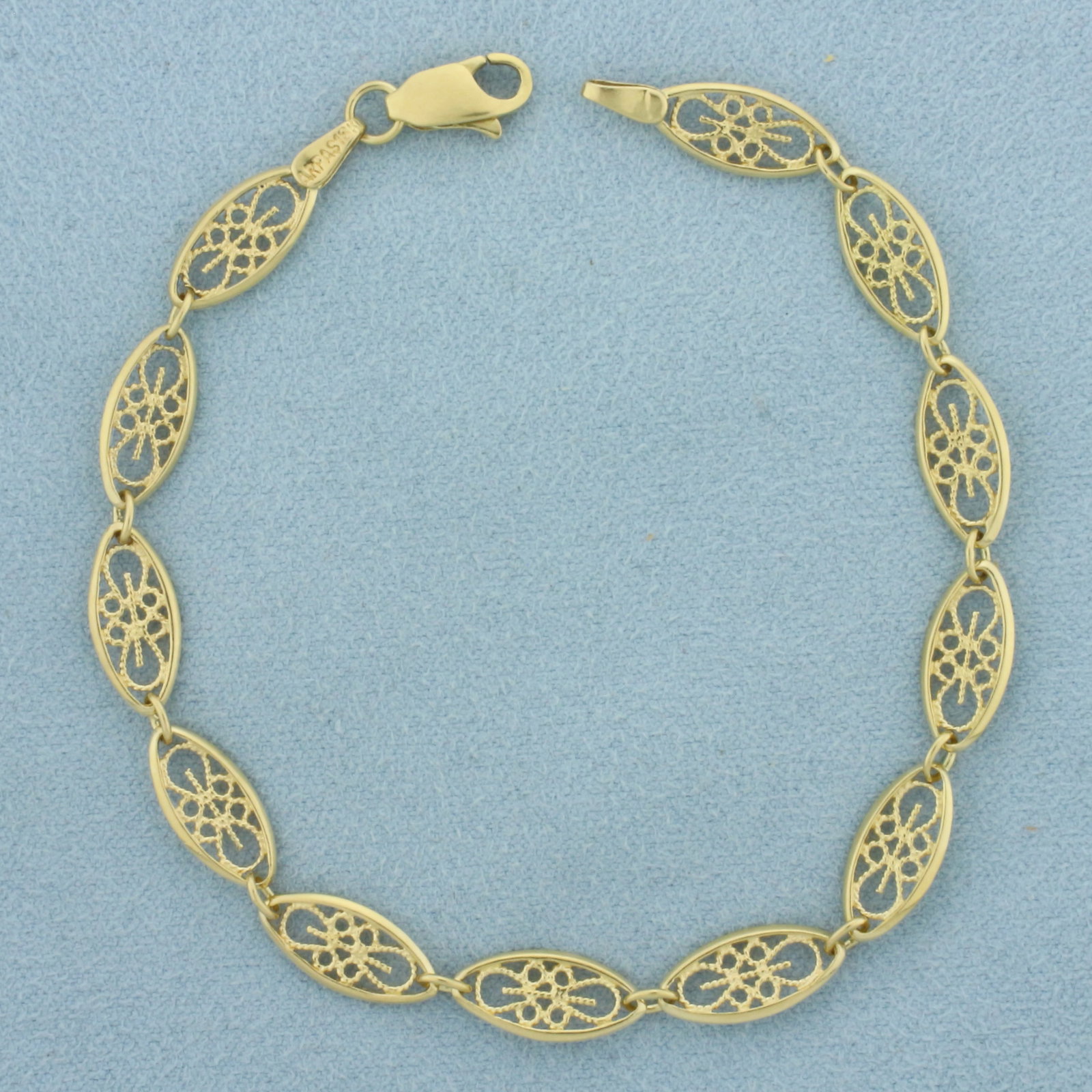 Oval Filigree Link Bracelet in 18k Yellow Gold: In 18k Yellow Gold. 7 7/8 inches long. 6.3mm wide. Lobster clasp. 6.0g.