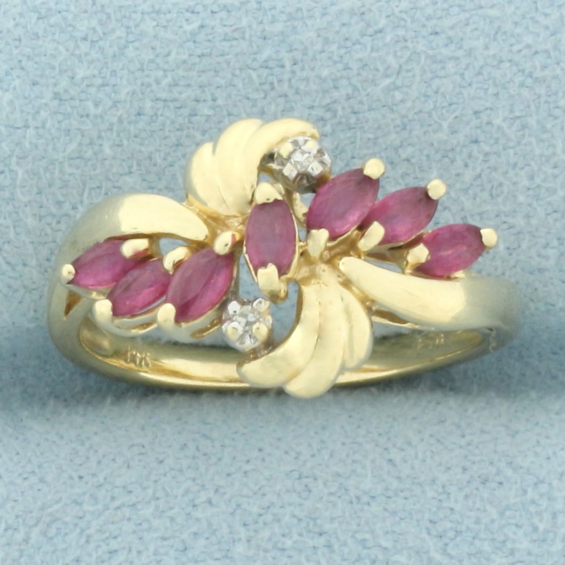 Ruby and Diamond Ring in 14k Yellow Gold: In 14k yellow gold. Contains seven high quality natural 4mm by 2mm Ruby gemstones with vibrant color. Also contains two high quality 1/2pt diamonds. Size: 6.5. 2.8g.
