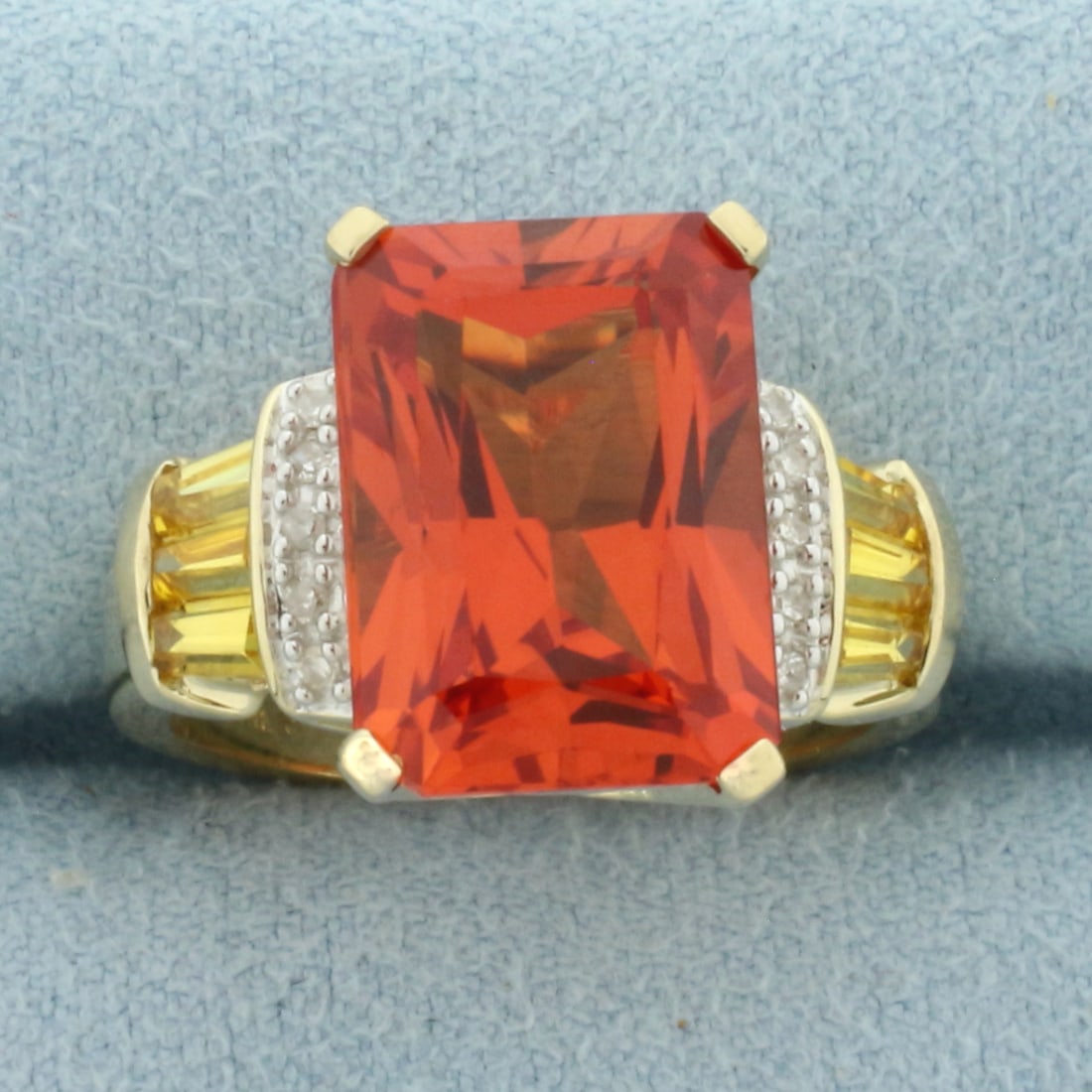 Lab Orange Sapphire and Diamond Ring in 10k Yellow Gold: In 10k Yellow Gold. Contains one 14x10mm high quality Lab Orange Sapphire gemstone, approximately 10cts, with intense color and excellent clarity. Also contains six 4x2mm high quality natural Yellow S