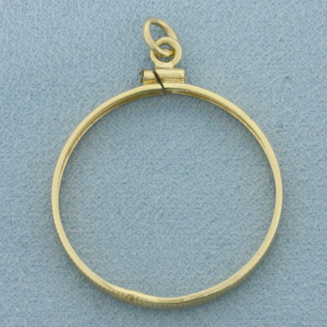 27mm Coin Holder Charm or Pendant for 1/oz Gold Eagle in 14k Yellow Gold: In 14k Yellow Gold. 1 3/8 inch long. 1 1/8 inch wide. Made for any 27mm coin like 1/2oz Gold Eagle. 1.7g.