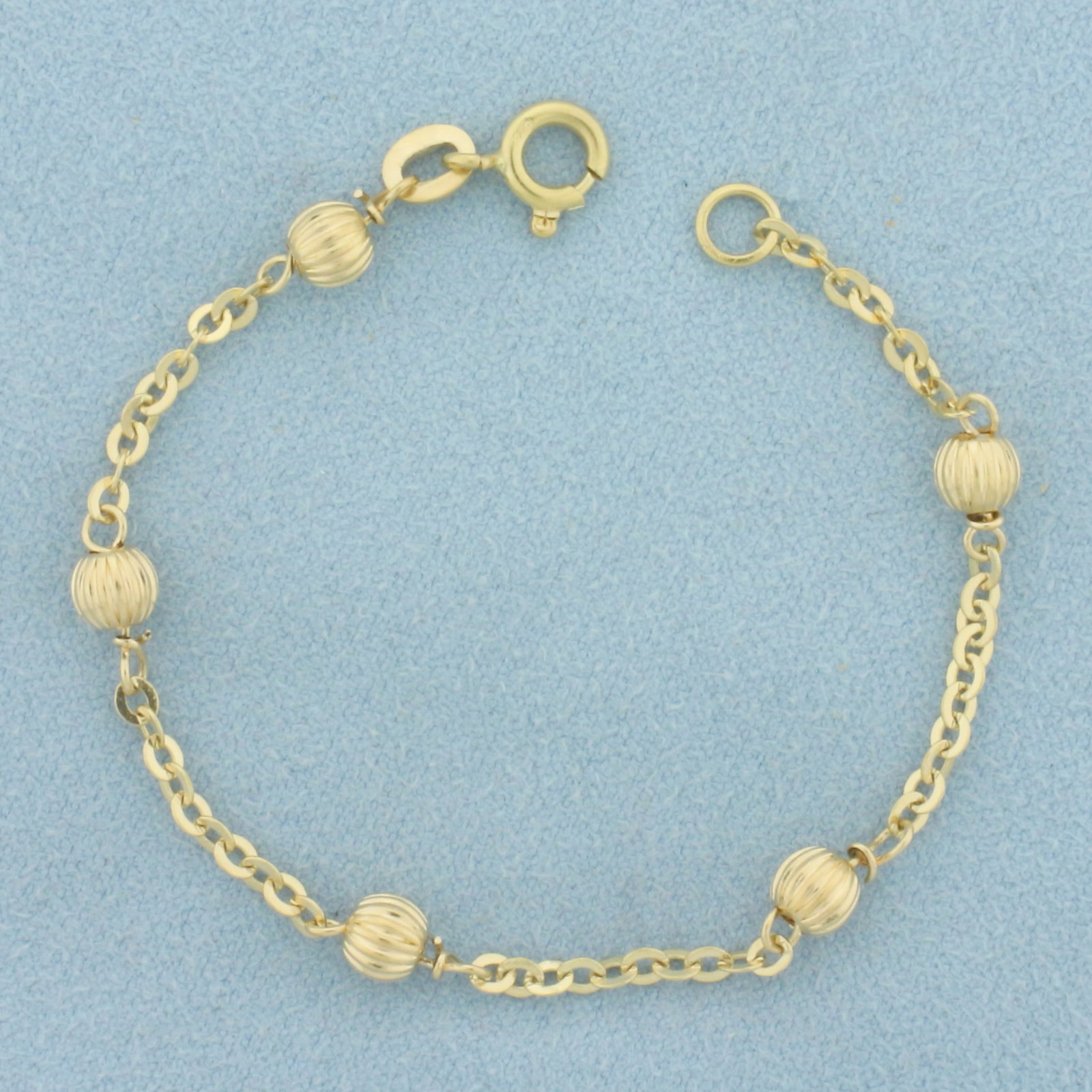 Ball Bead Cable Link Child Bracelet in 18k Yellow Gold: In 18k Yellow Gold. 5 1/2 inches long. 2.2mm wide chain. 4.5mm wide ball beads. Spring clasp. 2.5g.