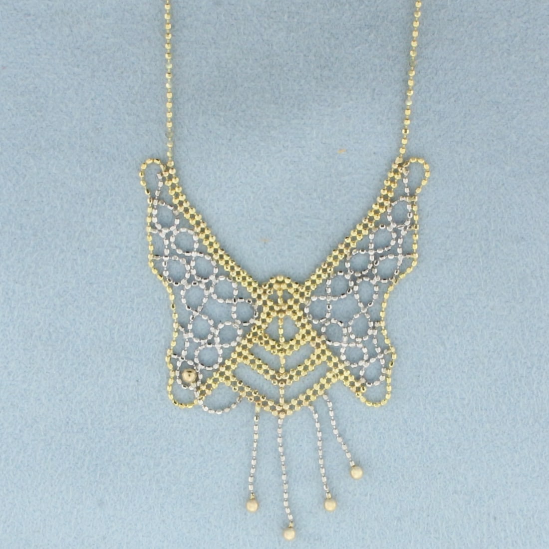 Butterfly Gold Bead Necklace in 10k Yellow and White Gold: In 10k Yellow and White Gold. 17 inches long. 1mm wide chain. 2 inch wide by 2 inch long butterfly center. Lobster clasp. 3.6g.