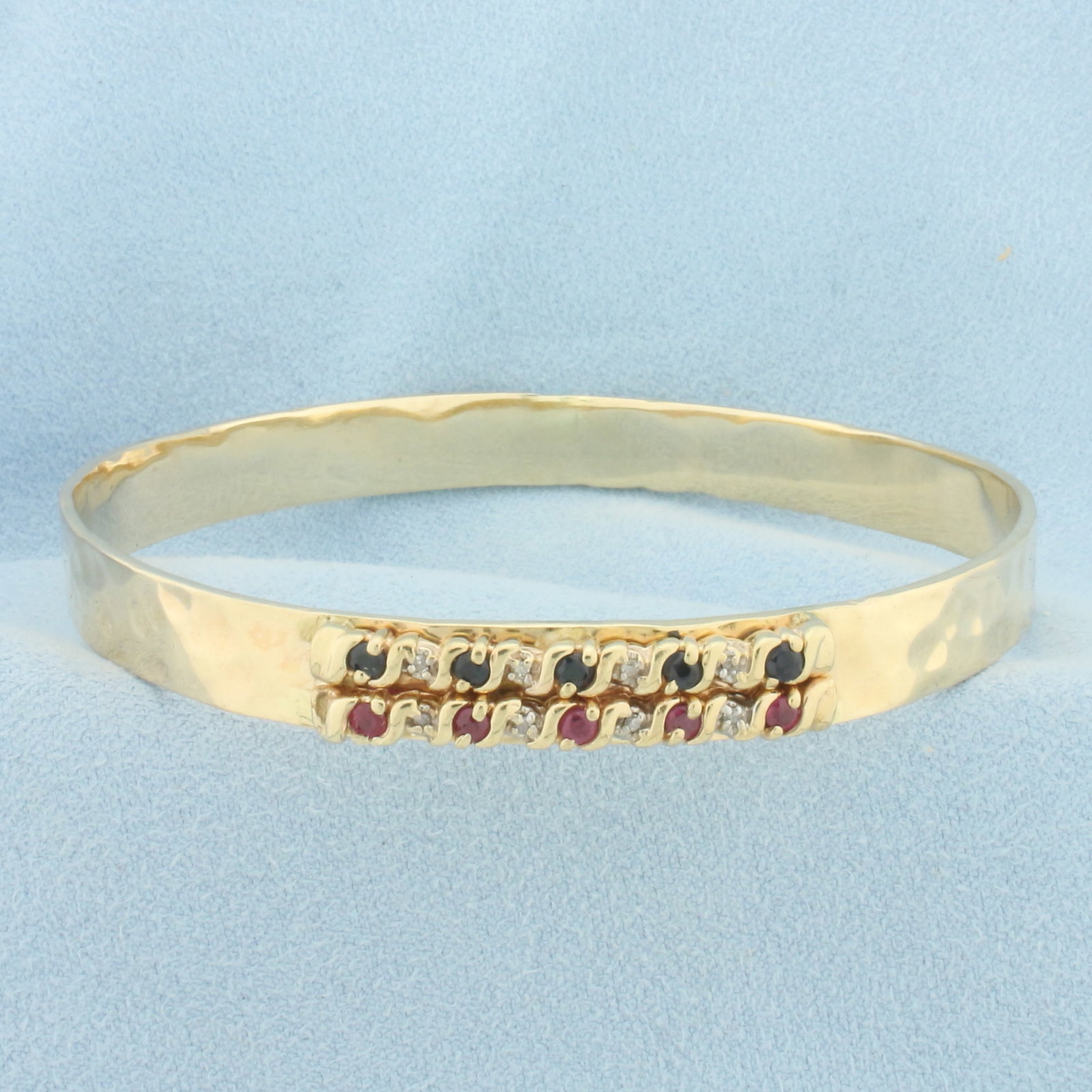 Ruby, Sapphire, and Diamond Bangle Bracelet in 14k Yellow Gold: In 14k yellow gold. 8mm wide with special hammered finish. Interior diameter is 2.75 inches by 2.625 inches. Contains 4 Ruby and 4 Sapphire 2mm high quality natural gemstones with intense color and ex