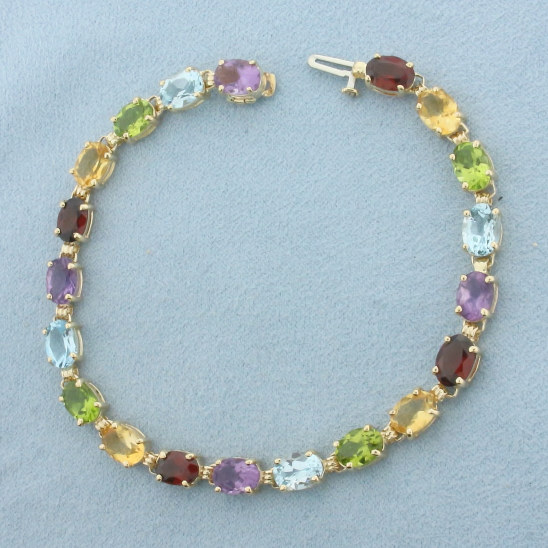 Rainbow Gemstone Tennis Bracelet in 14k Yellow Gold: In 14k Yellow Gold. 7 3/8 inches long. 5.2mm wide. Contains 20 high quality natural gemstones, 5x7mm each. Includes: garnet, citrine, peridot, blue topaz, and amethyst. Bright color and excellent clar