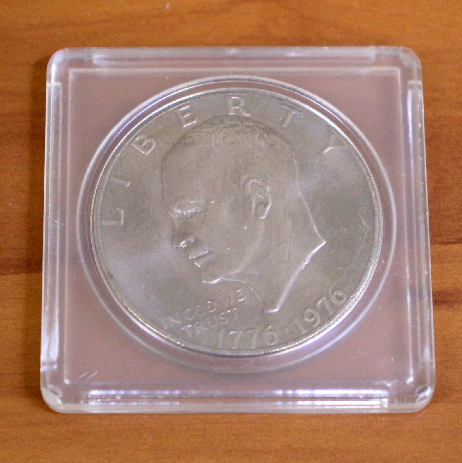 1976 Eisenhower Dollar Coin: 1776-1976 Bicentennial Eisenhower Dollar. Set in plastic casing.