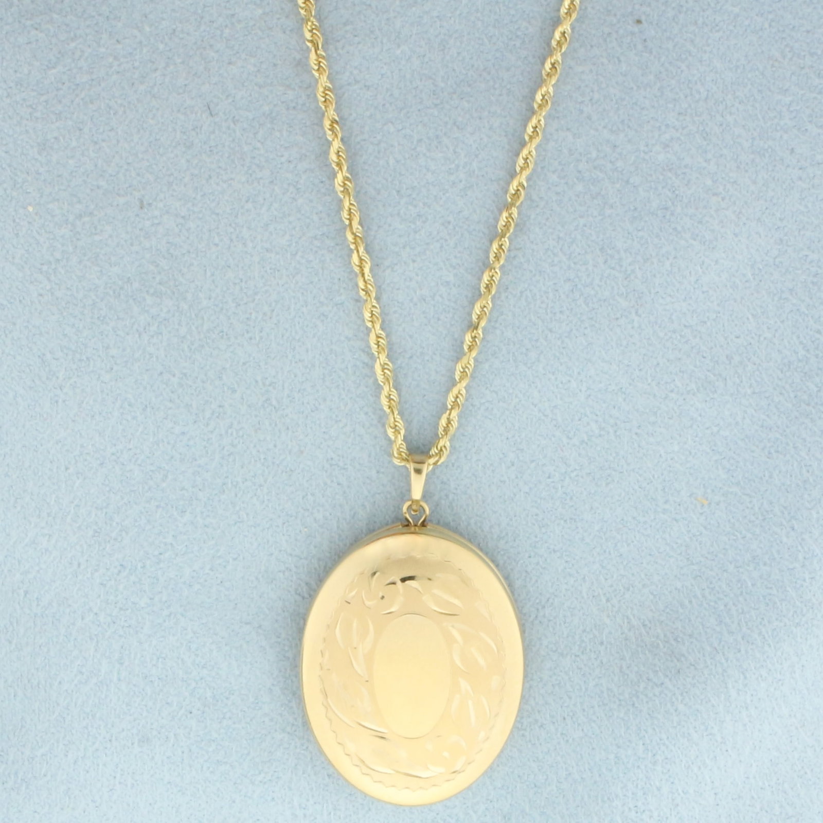 Oval Locket on Rope Chain Necklace in 14k Yellow Gold: In 14k Yellow Gold. Oval locket is 1 inch by 3/4 inch. Chain is 24 inch long rope link, 2mm wide. Lobster clasp. 10.0g