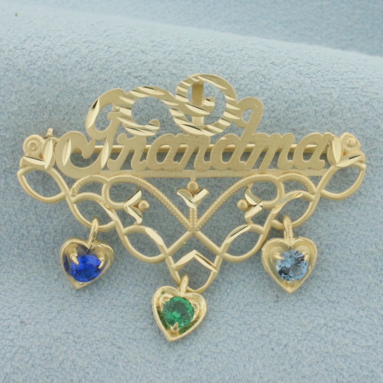 Grandma Topaz Pin in 14k Yellow Gold: In 14k yellow gold. Contains three high quality 3mm Topaz gemstones - light blue, royal blue, and emerald green with excellent clarity. 1 3/8 inches wide and 1 1/8 inches long. 3.2g.