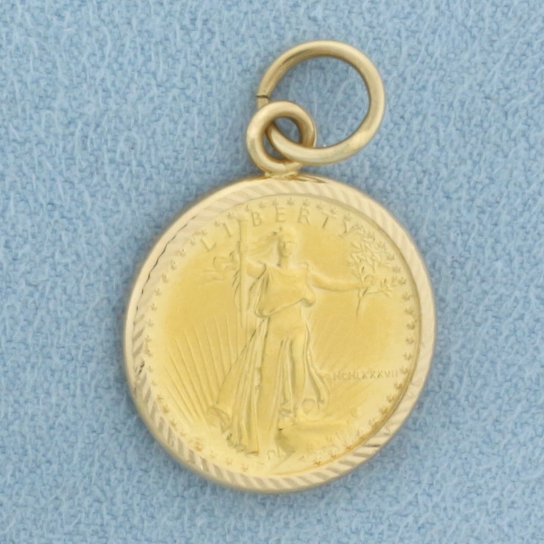 American Eagle $5 Gold Coin Charm in 14k Yellow Gold Bezel: In 14k Yellow Gold Bezel. Contains one 1/10 oz American Eagle $5 Gold Coin. 1 inch long (including jump ring). 5/8 inch wide. 4.3g.