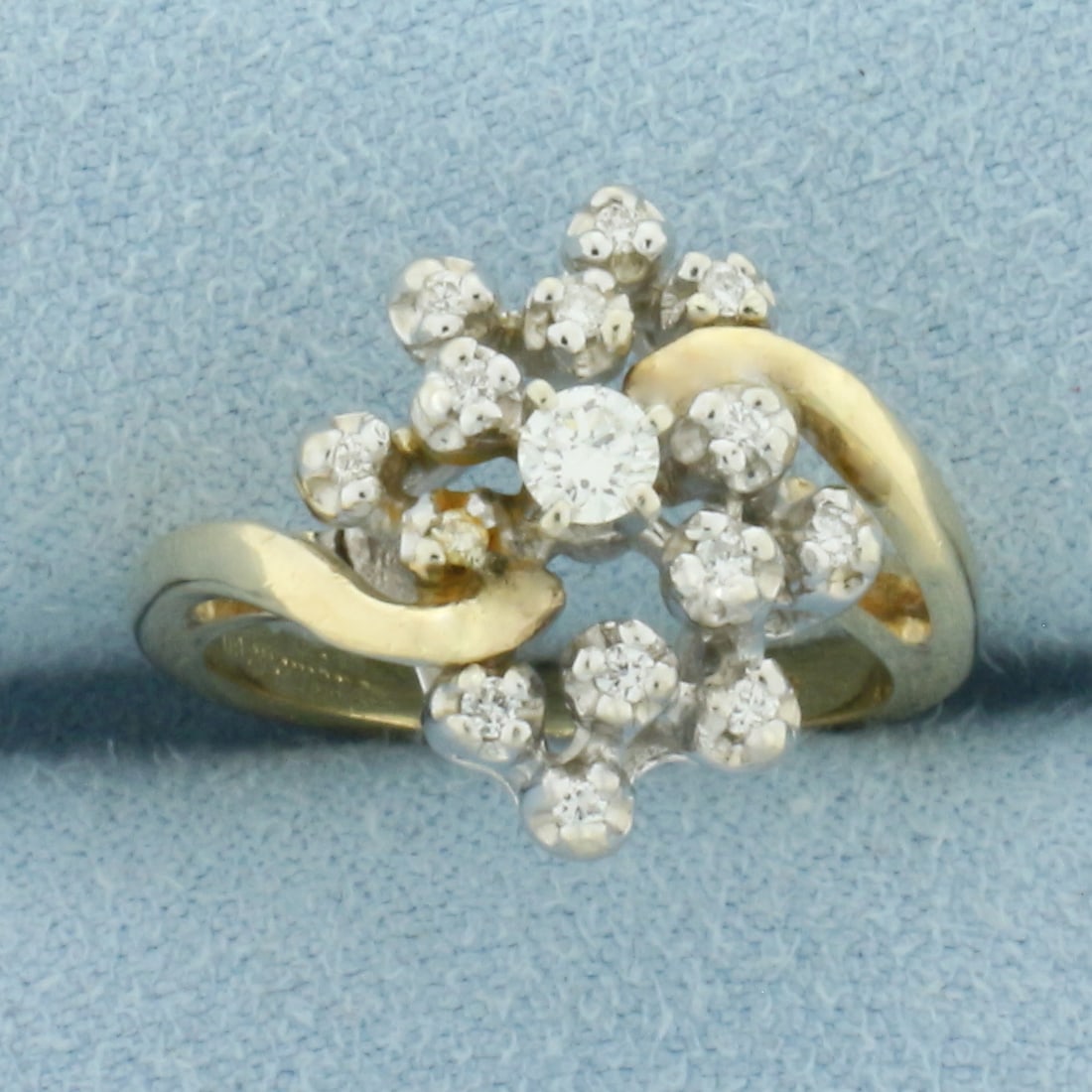 Diamond Cluster Ring in 14k Yellow Gold: In 14k Yellow Gold. Contains one 1/10ct and fourteen .01ct high quality diamonds, SI clarity/H color. 15.3mm wide across top of ring. Size 5.5. 5.1g.