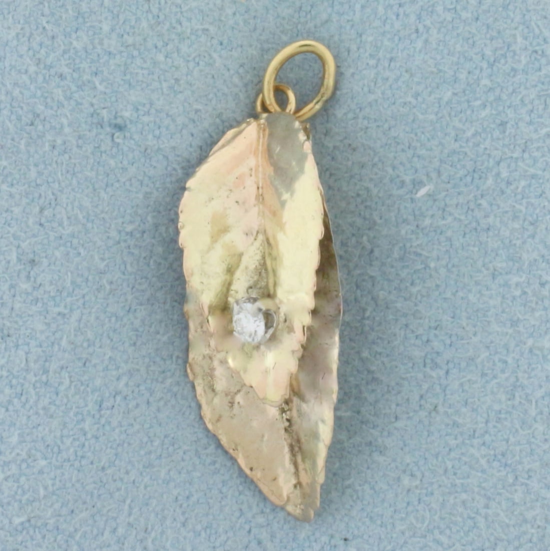 Diamond Leaf Charm in 14k Yellow Gold: In 14k Yellow Gold. Contains one .04ct high quality diamond, SI clarity/H color. 1 inch long (including jump ring). 3/8 inch wide.