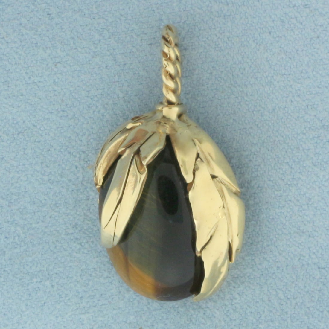 Tiger's Eye Leaf Design Pendant in 14K Yellow Gold: In 14k yellow gold. Measures 1.125 inches long (including bail) by 0.625 inches wide. Contains 1 high quality Tiger's Eye gemstone, 20mm by 16mm (approximately 11 carats). Signed - hand engraved on ba