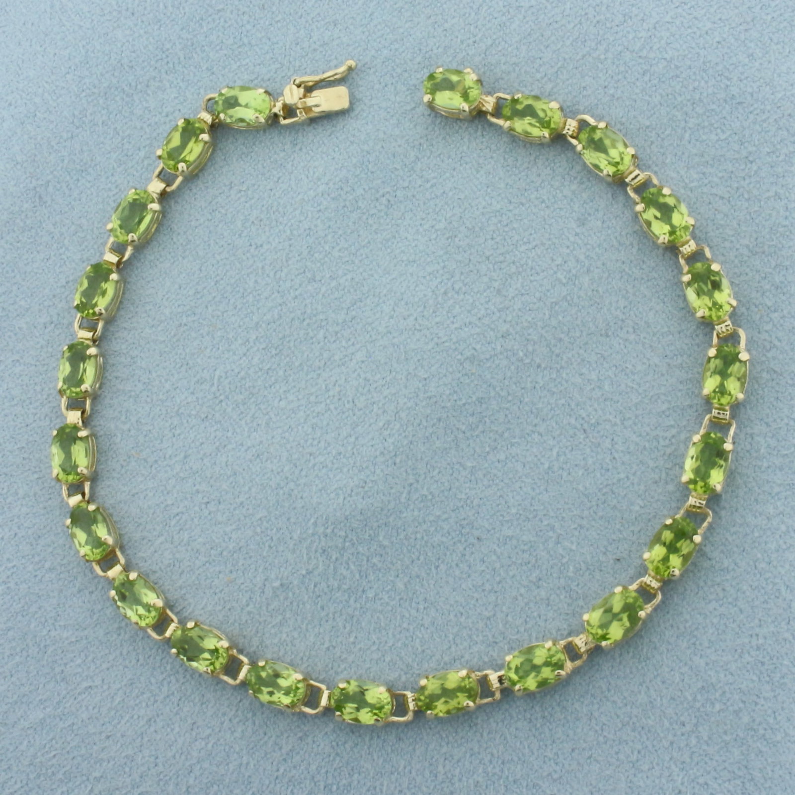 Peridot Tennis Bracelet in 10k Yellow Gold: In 10k Yellow Gold. 7.5 inches long. 4.4mm wide. Contains 22 high quality natural 6mm Peridot Gemstones, 11ct total weight, with bright color and excellent clarity. Concealed slide clasp with safety l
