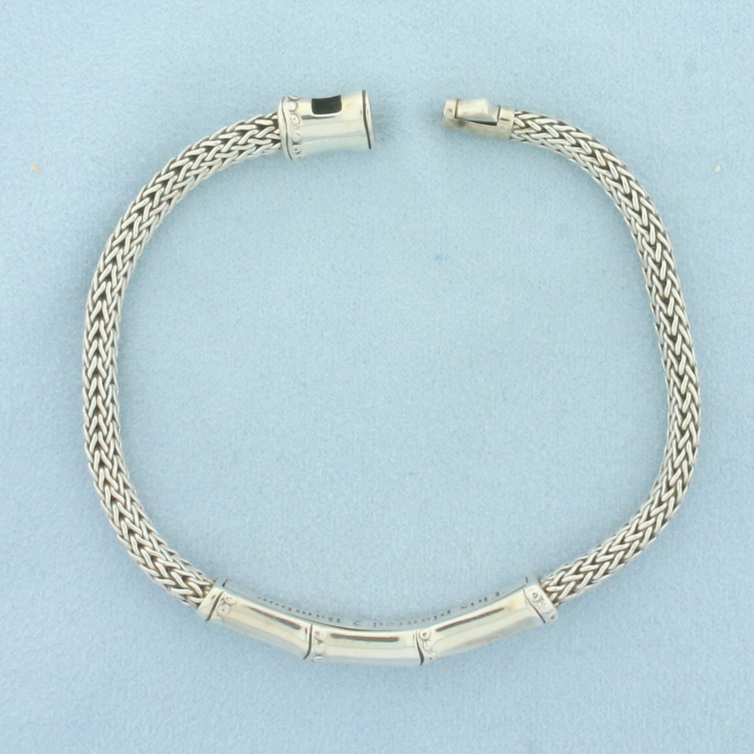 John Hardy Bamboo Bracelet in Sterling Silver: In .925 Sterling Silver. 8 inches long. 6.8mm wide at center. Bamboo line with signature "This Planted 2 Bamboo" engraving. Pusher clasp.